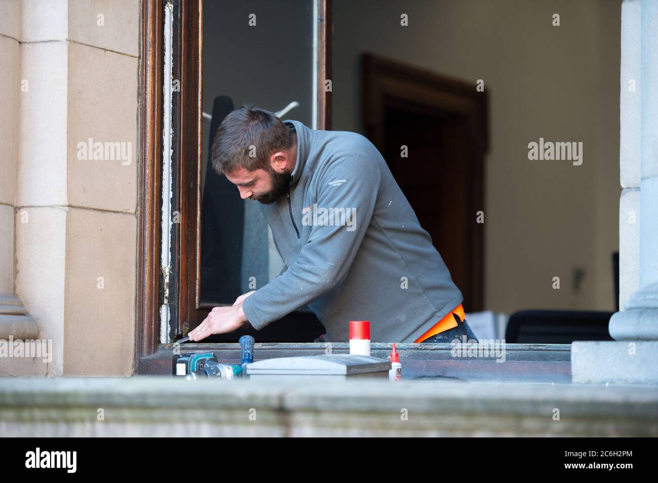 Glasgow, Schottland, Großbritannien. Juli 2020. Im Bild: Ein Tischler arbeitet an den Fenstern der Stadtkammern am George Square. Da die Sperre Bau- und Renovierungsarbeiten verhinderte, da die Sperre nachließ, können Tischler und Gewerke nun wieder an die Arbeit gehen, um die notwendige Wartung zu erledigen. Quelle: Colin Fisher/Alamy Live News Stockfoto