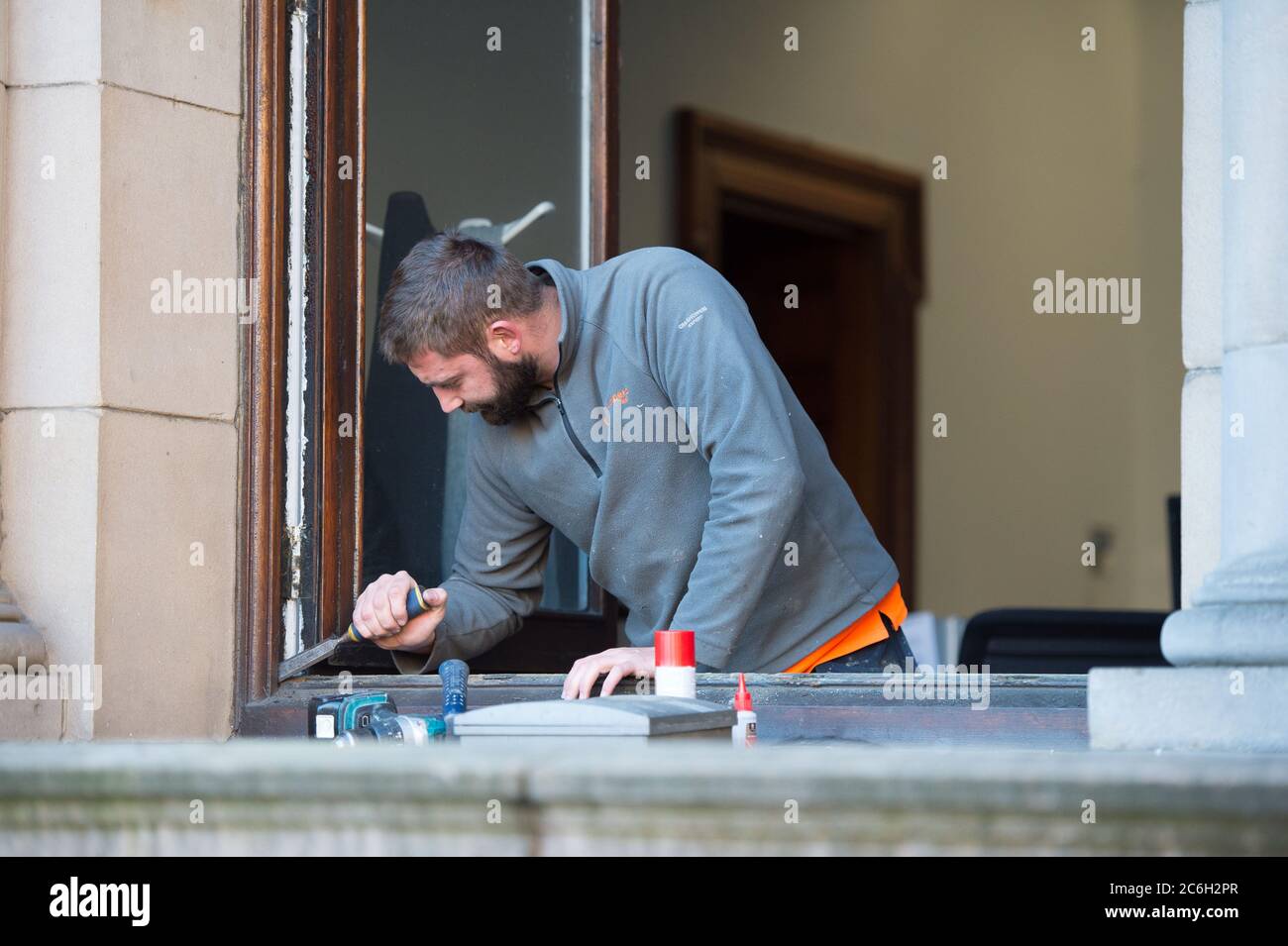 Glasgow, Schottland, Großbritannien. Juli 2020. Im Bild: Ein Tischler arbeitet an den Fenstern der Stadtkammern am George Square. Da die Sperre Bau- und Renovierungsarbeiten verhinderte, da die Sperre nachließ, können Tischler und Gewerke nun wieder an die Arbeit gehen, um die notwendige Wartung zu erledigen. Quelle: Colin Fisher/Alamy Live News Stockfoto