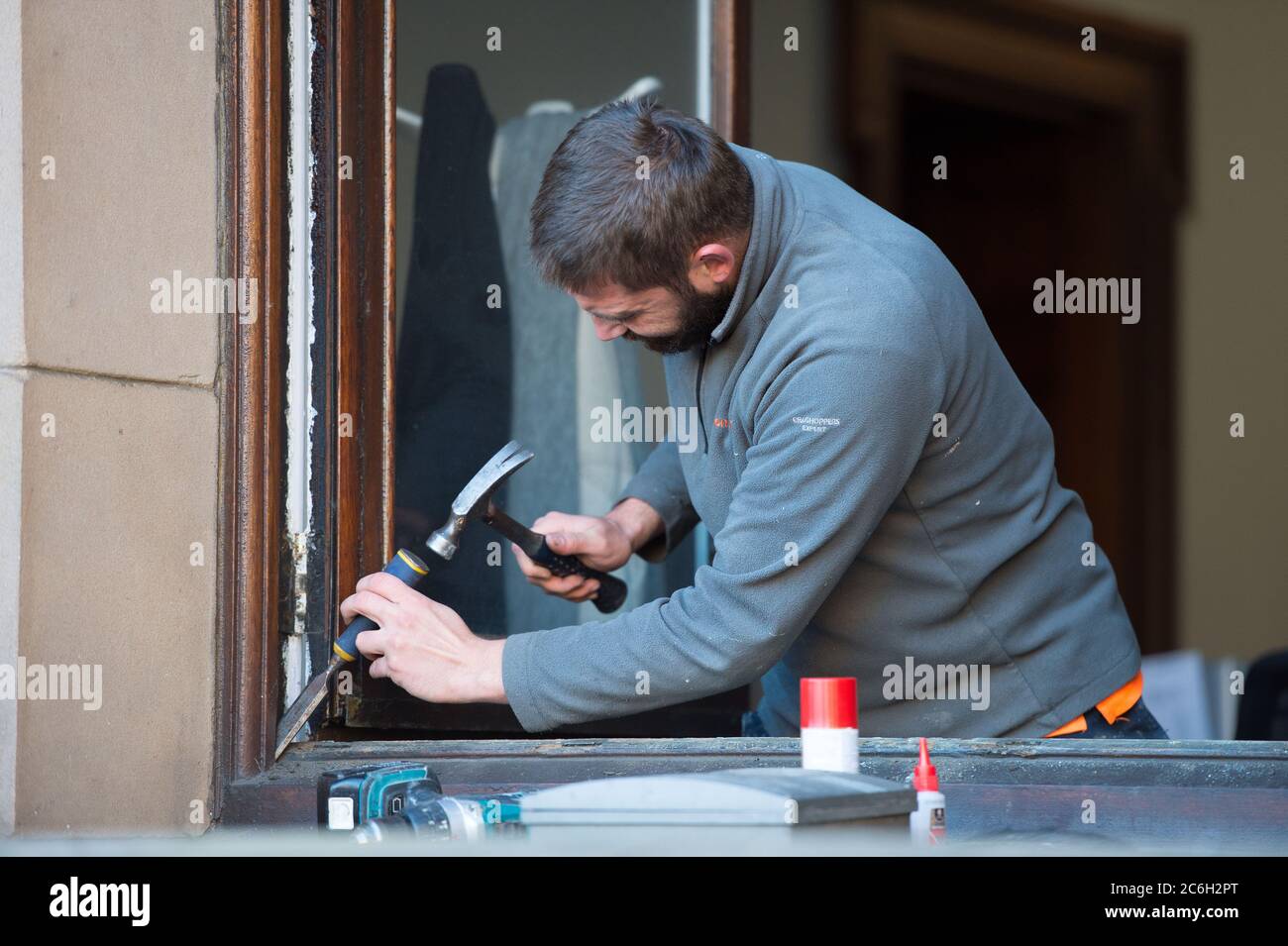 Glasgow, Schottland, Großbritannien. Juli 2020. Im Bild: Ein Tischler arbeitet an den Fenstern der Stadtkammern am George Square. Da die Sperre Bau- und Renovierungsarbeiten verhinderte, da die Sperre nachließ, können Tischler und Gewerke nun wieder an die Arbeit gehen, um die notwendige Wartung zu erledigen. Quelle: Colin Fisher/Alamy Live News Stockfoto