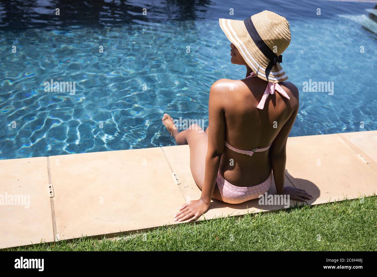 Rückansicht einer Frau, die am Pool saß Stockfoto