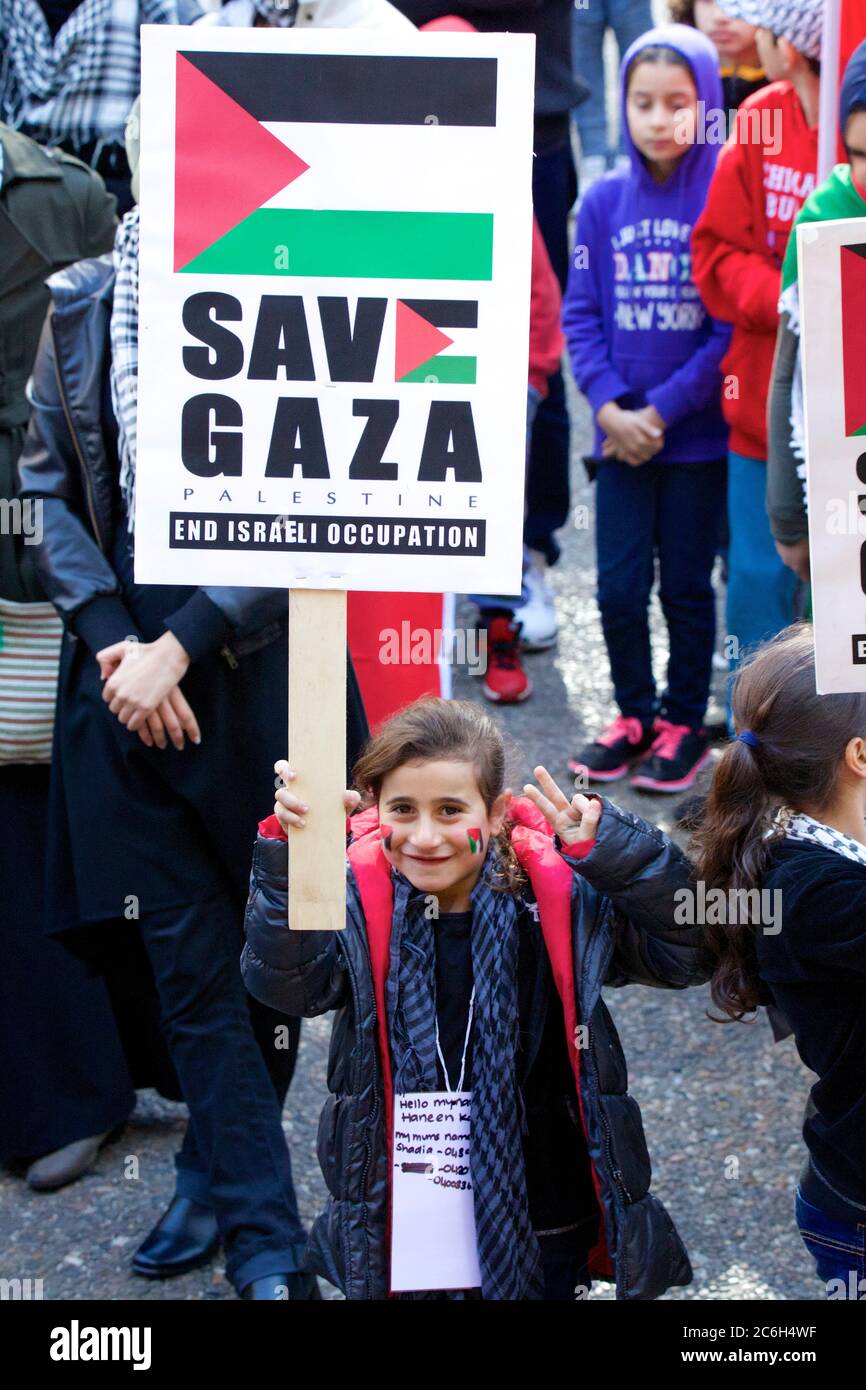 Ein junges Mädchen hält ein Schild mit der Aufschrift: ‘SAve Gaza Palestine. End Israeli Occupation’ und sie hat ein Zeichen um ihren Hals mit dem, was scheint, ihre Mutter zu sein Stockfoto