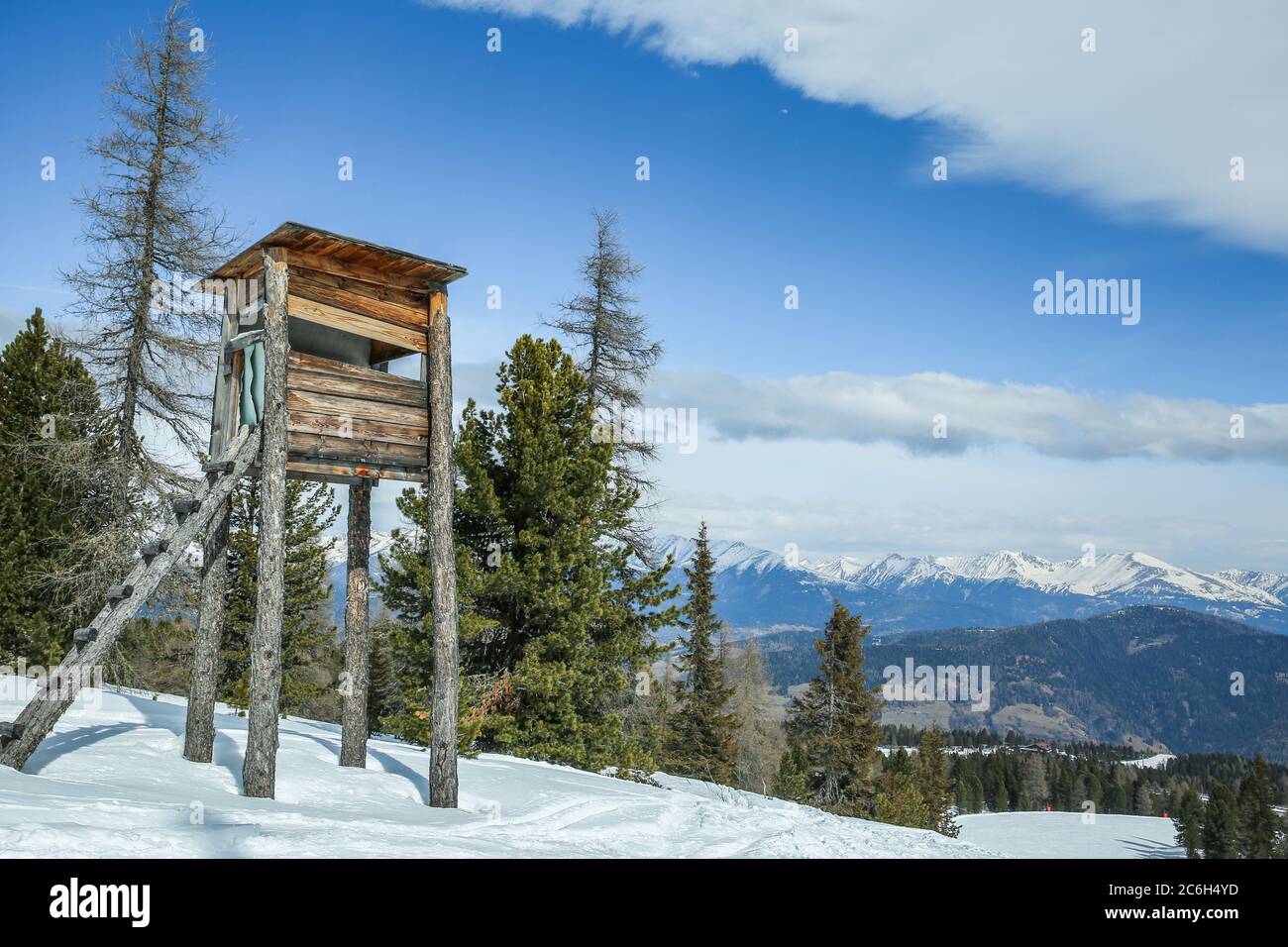 Holzjagdturm im Winterwald in den Bergen Stockfoto