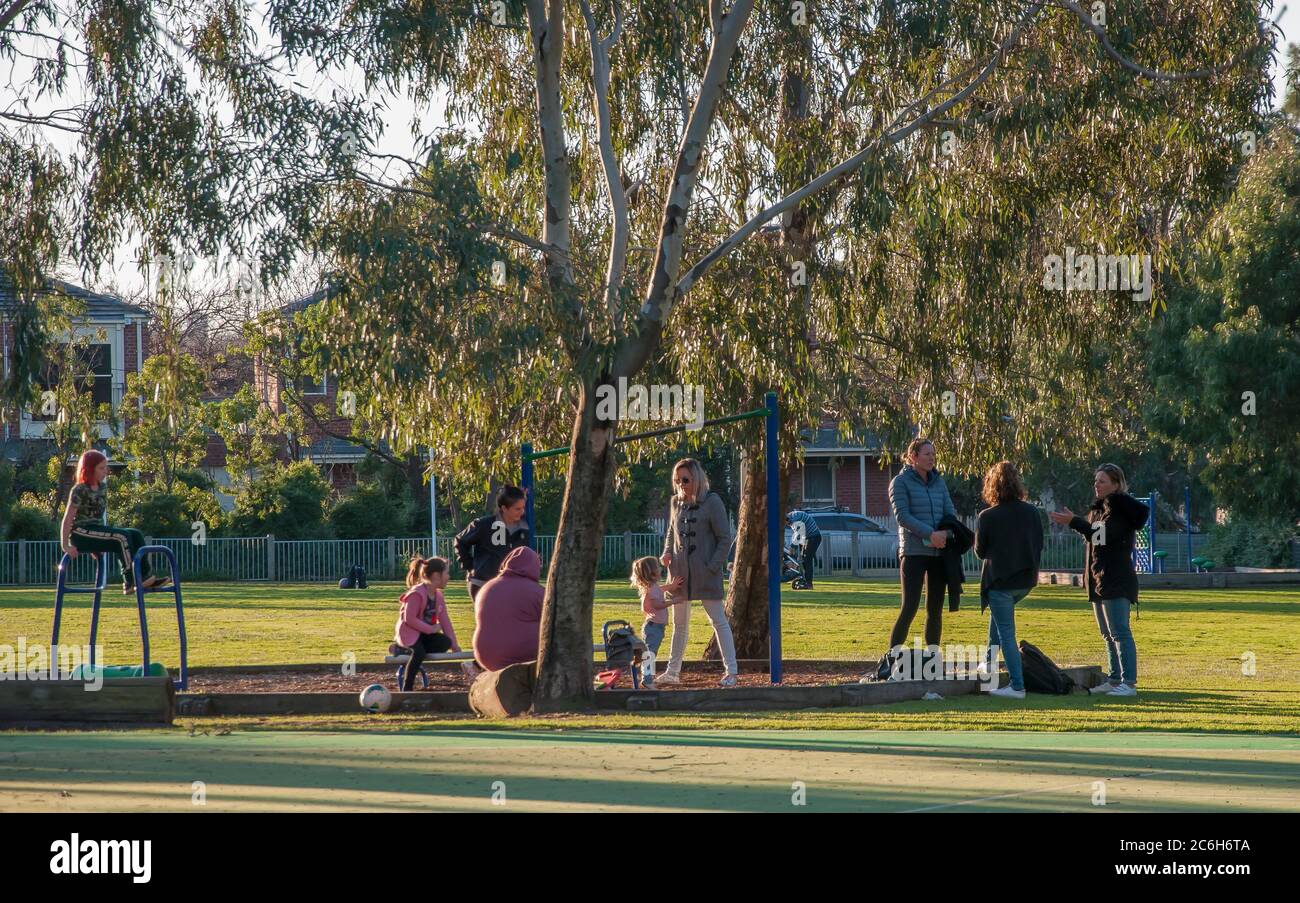 Kinder und Eltern treffen sich am späten Nachmittag auf dem Schulhof der Elwood Primary School, Melbourne, Australien. Stockfoto