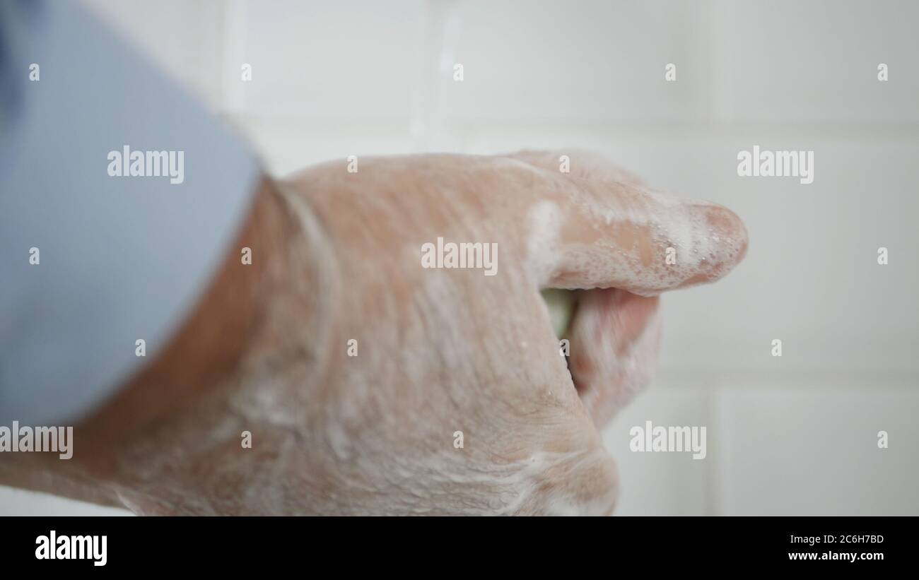 Person, die seine Hände mit Seife und Wasser wäscht, reinigt und desinfiziert gegen Viren und Krankheiten Stockfoto