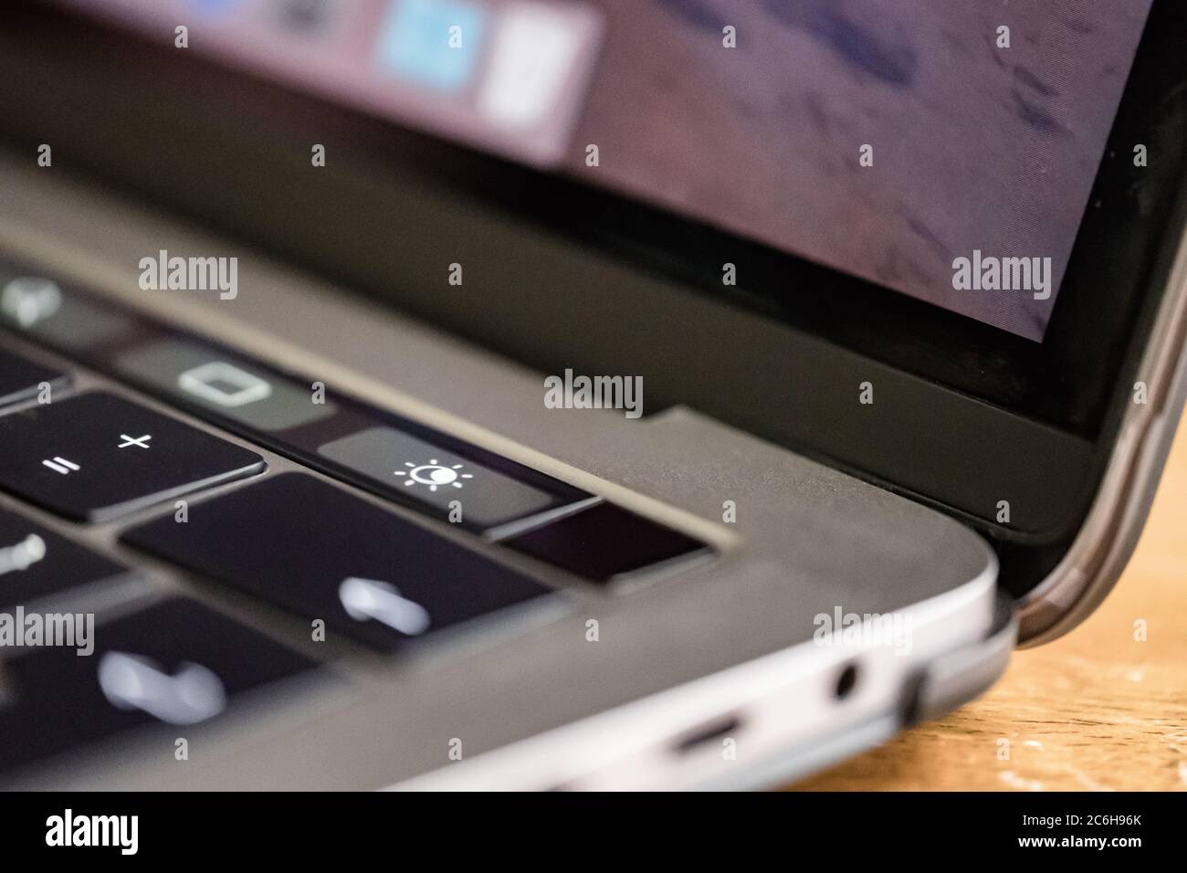 Nahaufnahme, geringer Fokus einer hintergrundbeleuchteten Tastatur, die auf einem bekannten, luxuriösen Computerhersteller zu sehen ist. Stockfoto