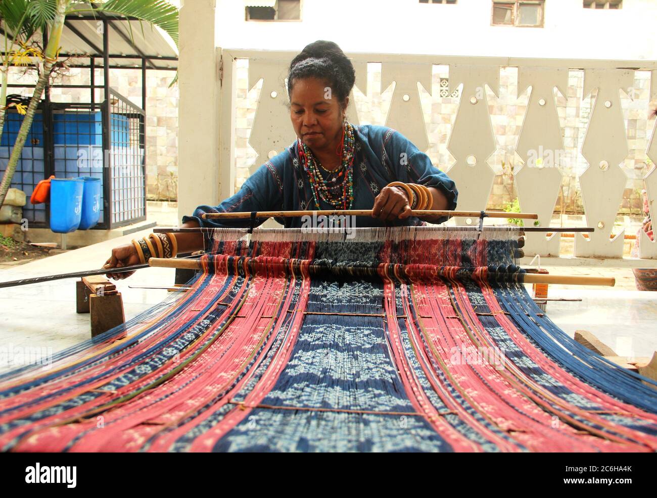 Eine Frau, die eine schöne Decke mit einem traditionellen Handwerkszeug macht Stockfoto