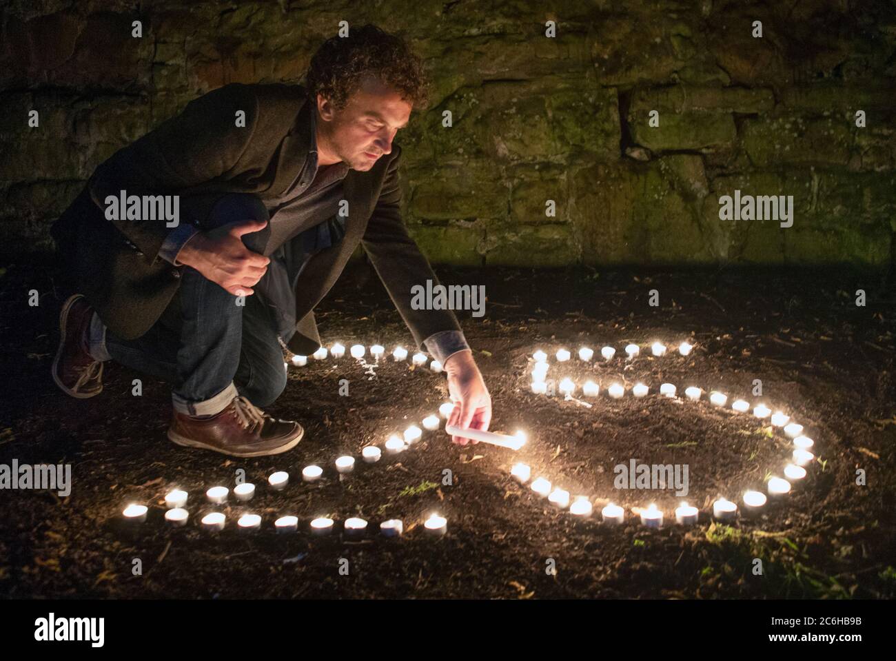 Der preisgekrönte Regisseur Samir Mehanovic, der 1995 als Einwanderer aus dem Bosnienkrieg nach Großbritannien kam und heute in Edinburgh lebt, zündet Kerzen an, um dem 25. Jahrestag des Genozids in Srebrenica zu gedenken. Stockfoto