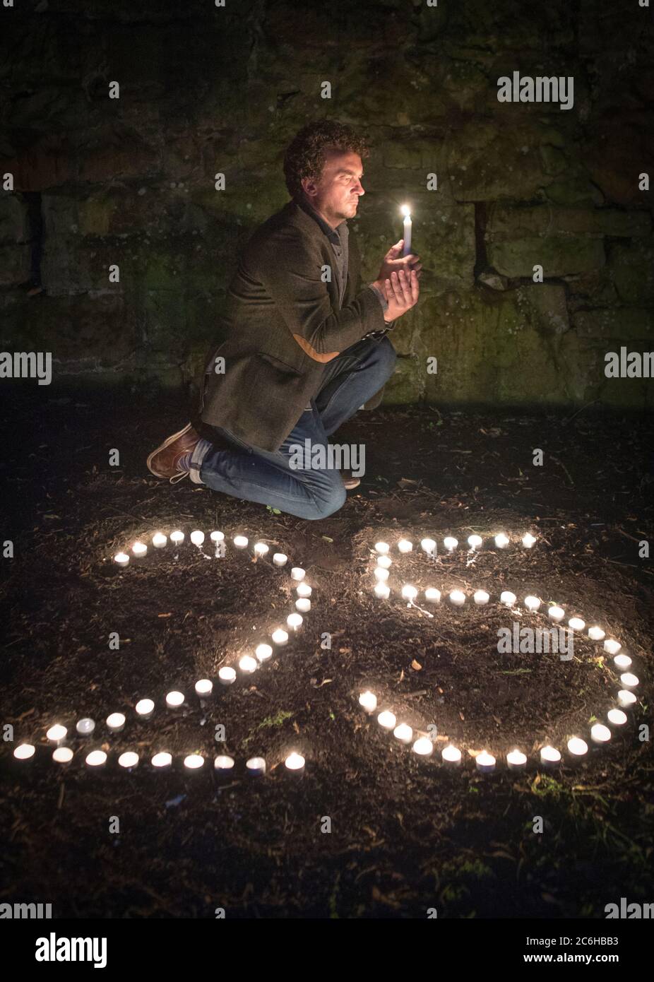 Der preisgekrönte Regisseur Samir Mehanovic, der 1995 als Einwanderer aus dem Bosnienkrieg nach Großbritannien kam und heute in Edinburgh lebt, zündet Kerzen an, um dem 25. Jahrestag des Genozids in Srebrenica zu gedenken. Stockfoto