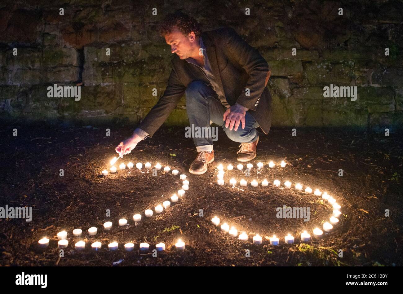 Der preisgekrönte Regisseur Samir Mehanovic, der 1995 als Einwanderer aus dem Bosnienkrieg nach Großbritannien kam und heute in Edinburgh lebt, zündet Kerzen an, um dem 25. Jahrestag des Genozids in Srebrenica zu gedenken. Stockfoto