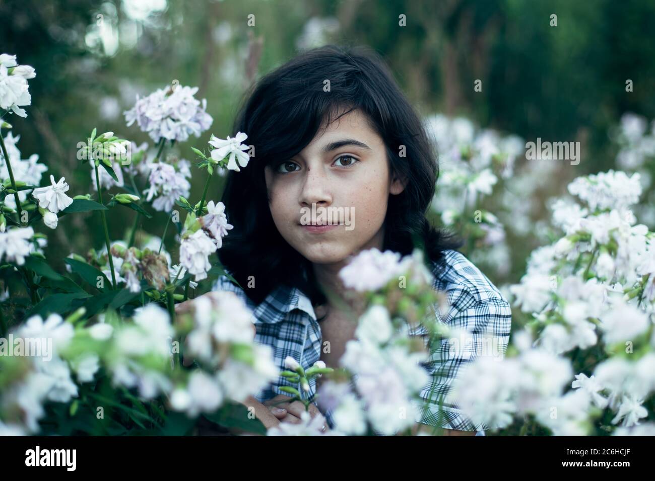 Ein Teenager Mädchen im Garten zwischen Blumen. Stockfoto