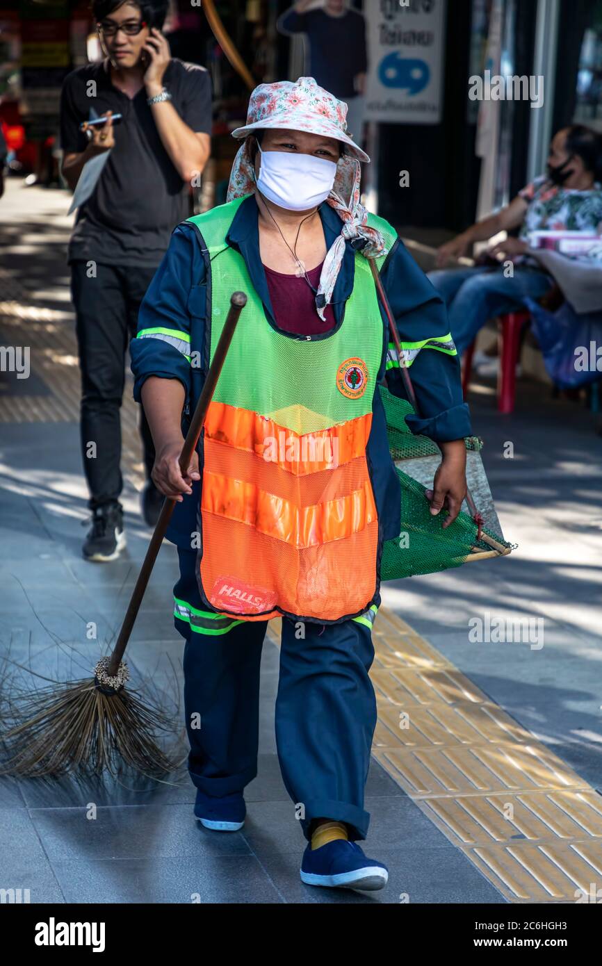 Straßenreiniger trägt Gesichtsmaske und gut sichtbare Kleidung während covid 19 Pandemie, Bangkok, Thailand Stockfoto