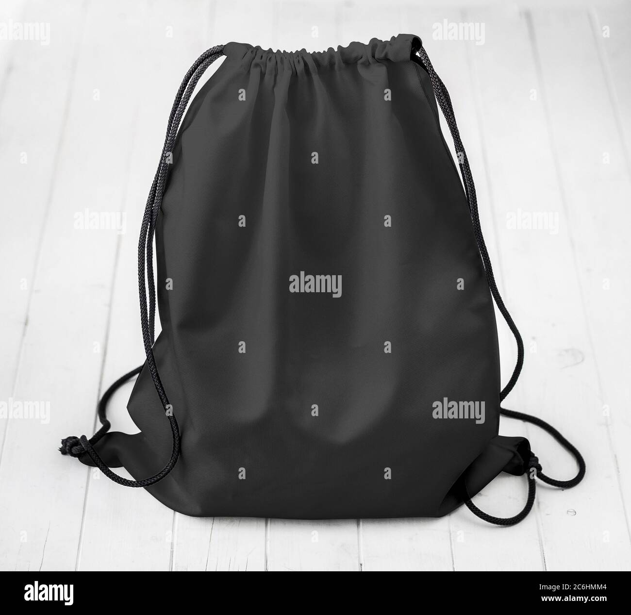 Schwarzer Rucksack mit Schnüren auf Planken Stockfoto
