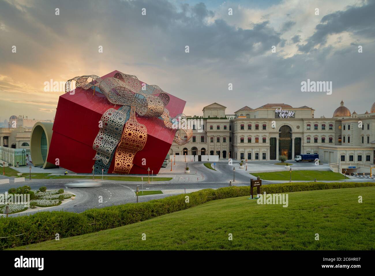 Katara Kulturdorf in Doha Katar luxuriöse Einkaufszentrum außen Sonnenuntergangsaufnahme, die den Eingang mit Leuten und Autos zeigt Die Straße Stockfoto