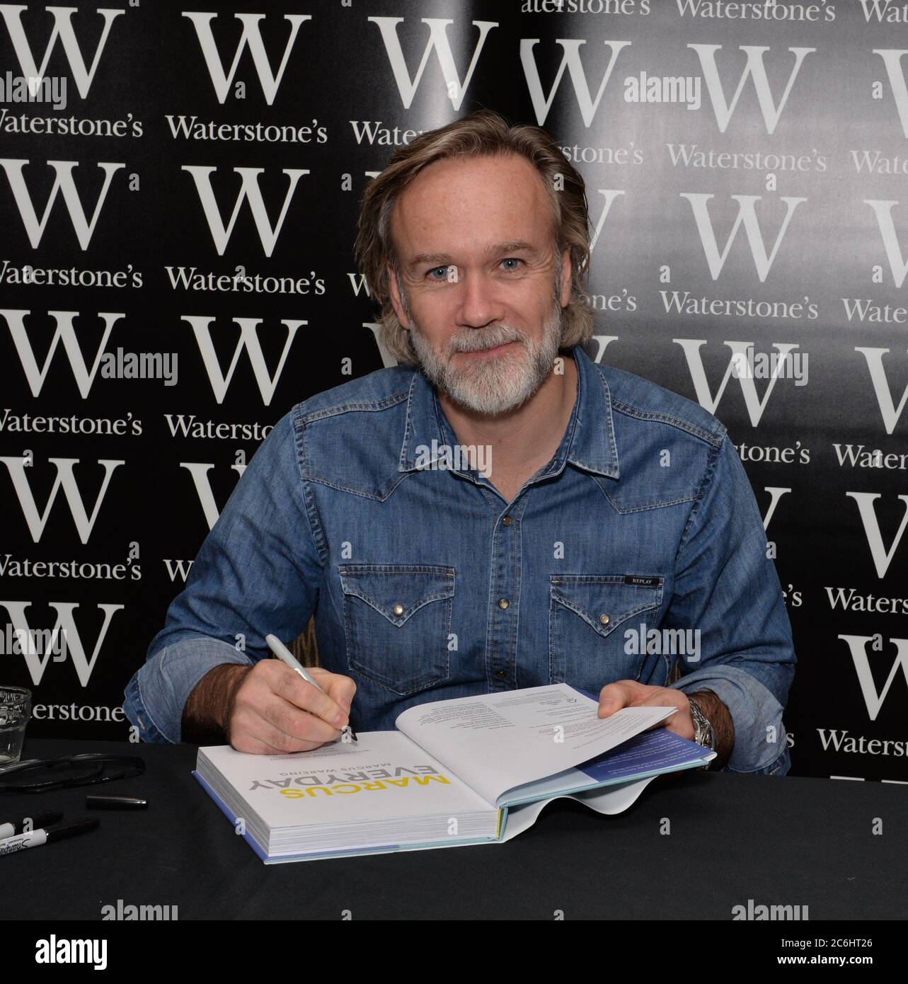 Marcus Wareing, ein Michelin-Sternekoch, signiert Kopien seines neuen Rezeptes Marcus Everyday, das leichte Mahlzeiten für jeden Tag der Woche bietet. Waterstone Stockfoto