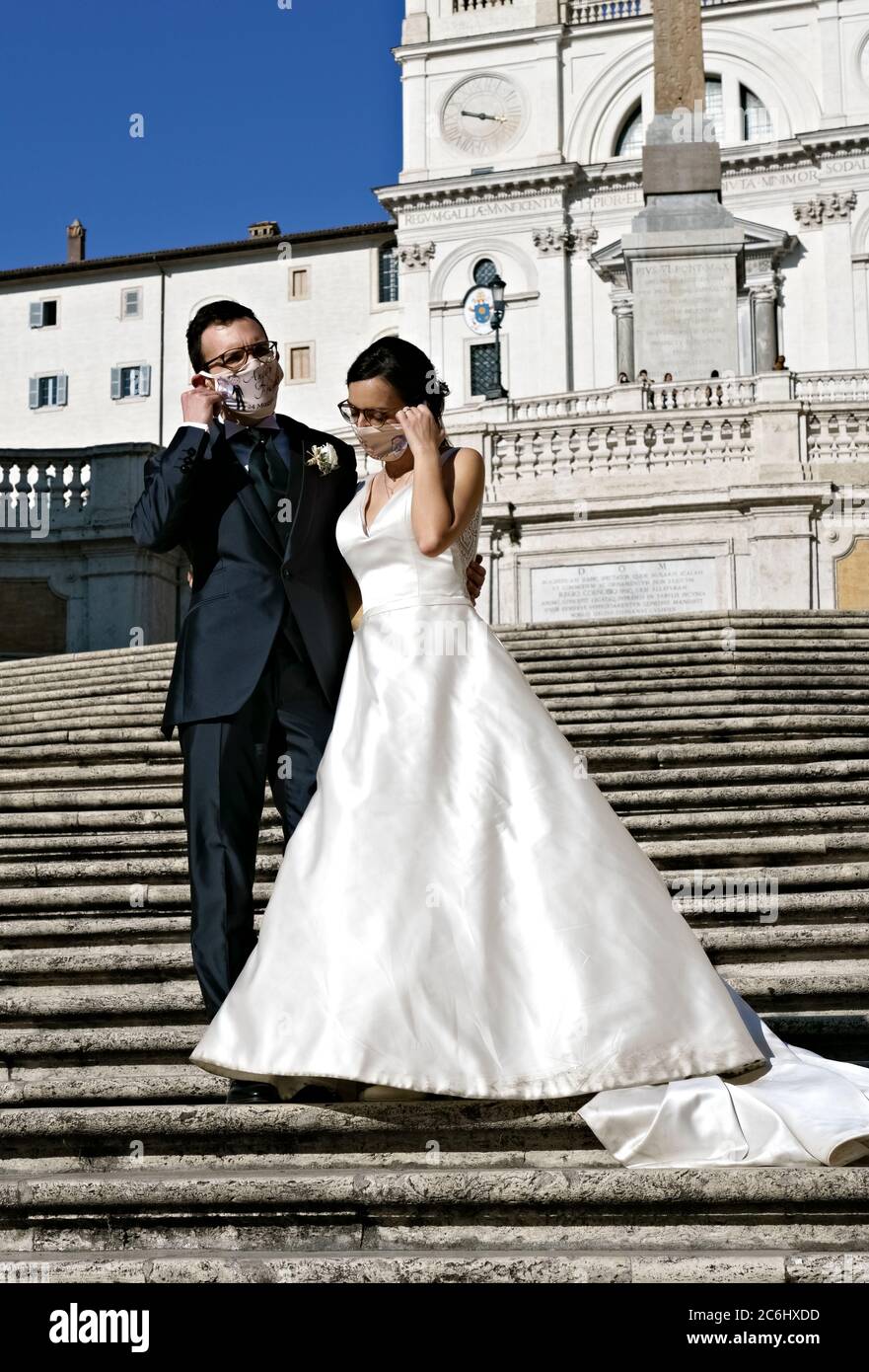 Frisch verheiratetes Paar mit medizinischer Maske Coronavirus, posiert für das Fotografieren auf der Spanischen Treppe. Hochzeit zur Zeit von Covid 19 Rom Italien Europa Stockfoto