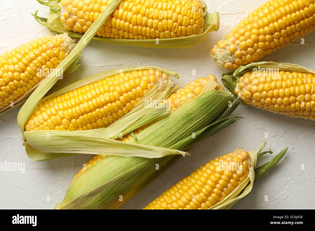 Frischer roher Mais auf weißem Hintergrund, Draufsicht Stockfoto