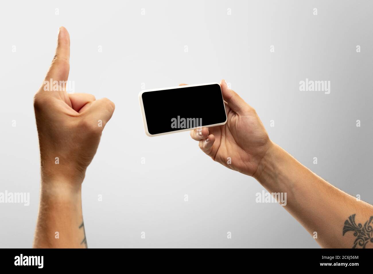 Spannende Momente. Nahaufnahme männliche Hände halten Telefon mit leerem Bildschirm während Online-Wiedergabe von beliebten Sportspielen, Meisterschaften. Copyspace für Werbung. Geräte, Gadgets, Technologien Konzept. Stockfoto