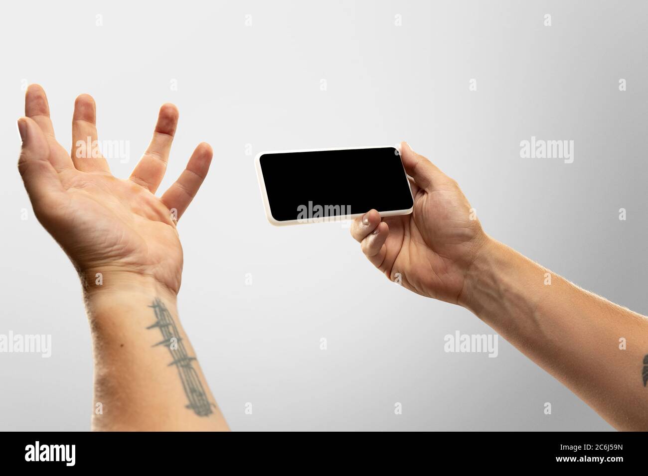 Spannende Momente. Nahaufnahme männliche Hände halten Telefon mit leerem Bildschirm während Online-Wiedergabe von beliebten Sportspielen, Meisterschaften. Copyspace für Werbung. Geräte, Gadgets, Technologien Konzept. Stockfoto