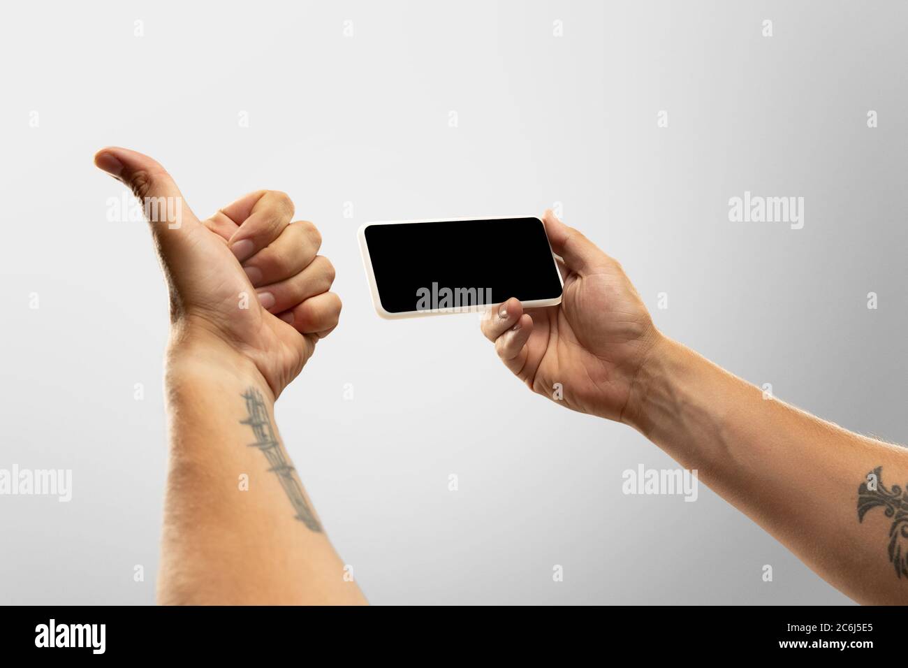 Spannende Momente. Nahaufnahme männliche Hände halten Telefon mit leerem Bildschirm während Online-Wiedergabe von beliebten Sportspielen, Meisterschaften. Copyspace für Werbung. Geräte, Gadgets, Technologien Konzept. Stockfoto