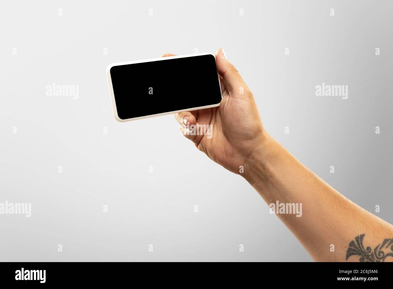 Spannende Momente. Nahaufnahme männliche Hände halten Telefon mit leerem Bildschirm während Online-Wiedergabe von beliebten Sportspielen, Meisterschaften. Copyspace für Werbung. Geräte, Gadgets, Technologien Konzept. Stockfoto