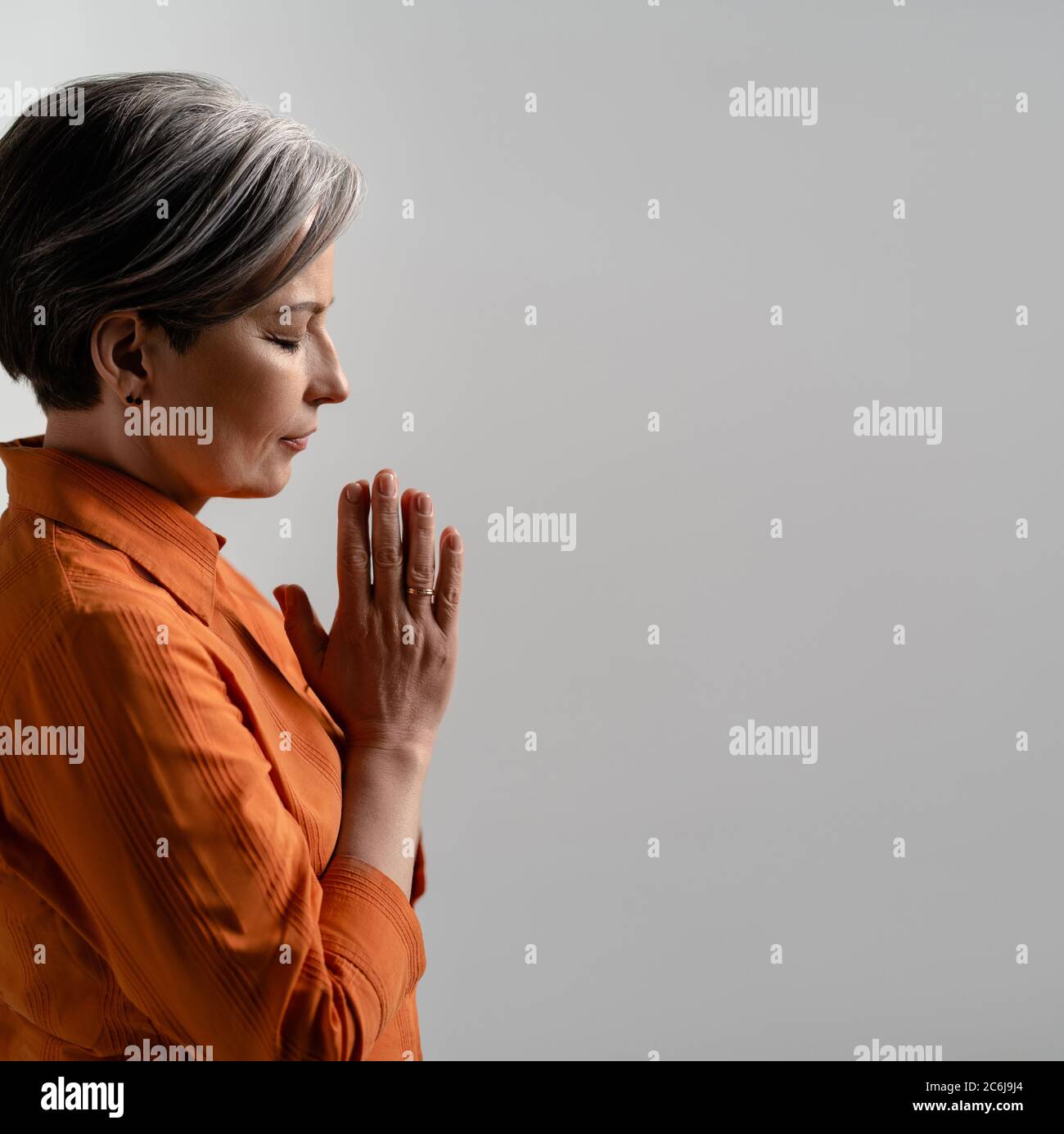 Spirituelle kaukasische Frau betet mit zusammengekrallten Händen. Seitenansicht einer meditierenden reifen Frau mit geschlossenen Augen. Quadratische Form mit Kopierfläche für soziale Medien Stockfoto Spirituelle kaukasische Frau betet mit zusammengekrallten Händen. Seitenansicht einer meditierenden reifen Frau mit geschlossenen Augen. Quadratische Form mit Kopierfläche für soziale Medien Stockfoto