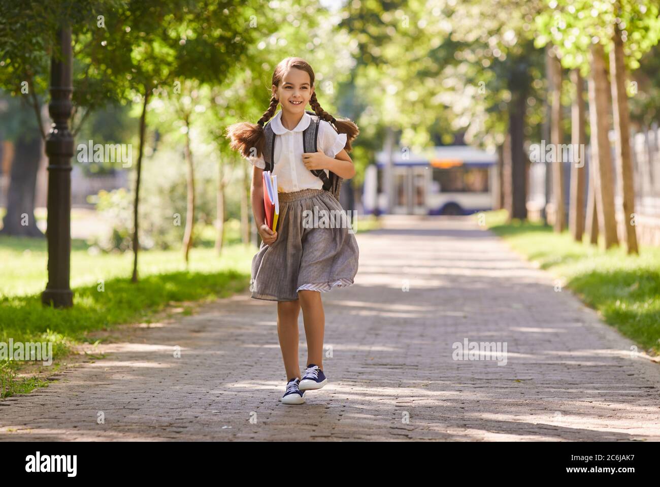 Zurück zur Schule. Schulmädchen lächelt fröhlich geht zur Schule in der früh. Stockfoto