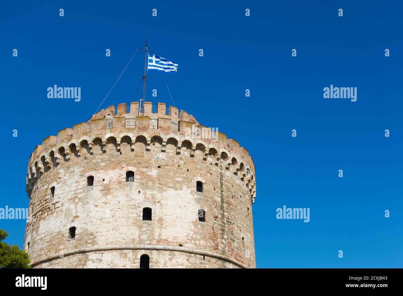 Der Weiße Turm in Thessaloniki mit wehender griechischer Flagge, Griechenland. Griechisches Wahrzeichen Stockfoto