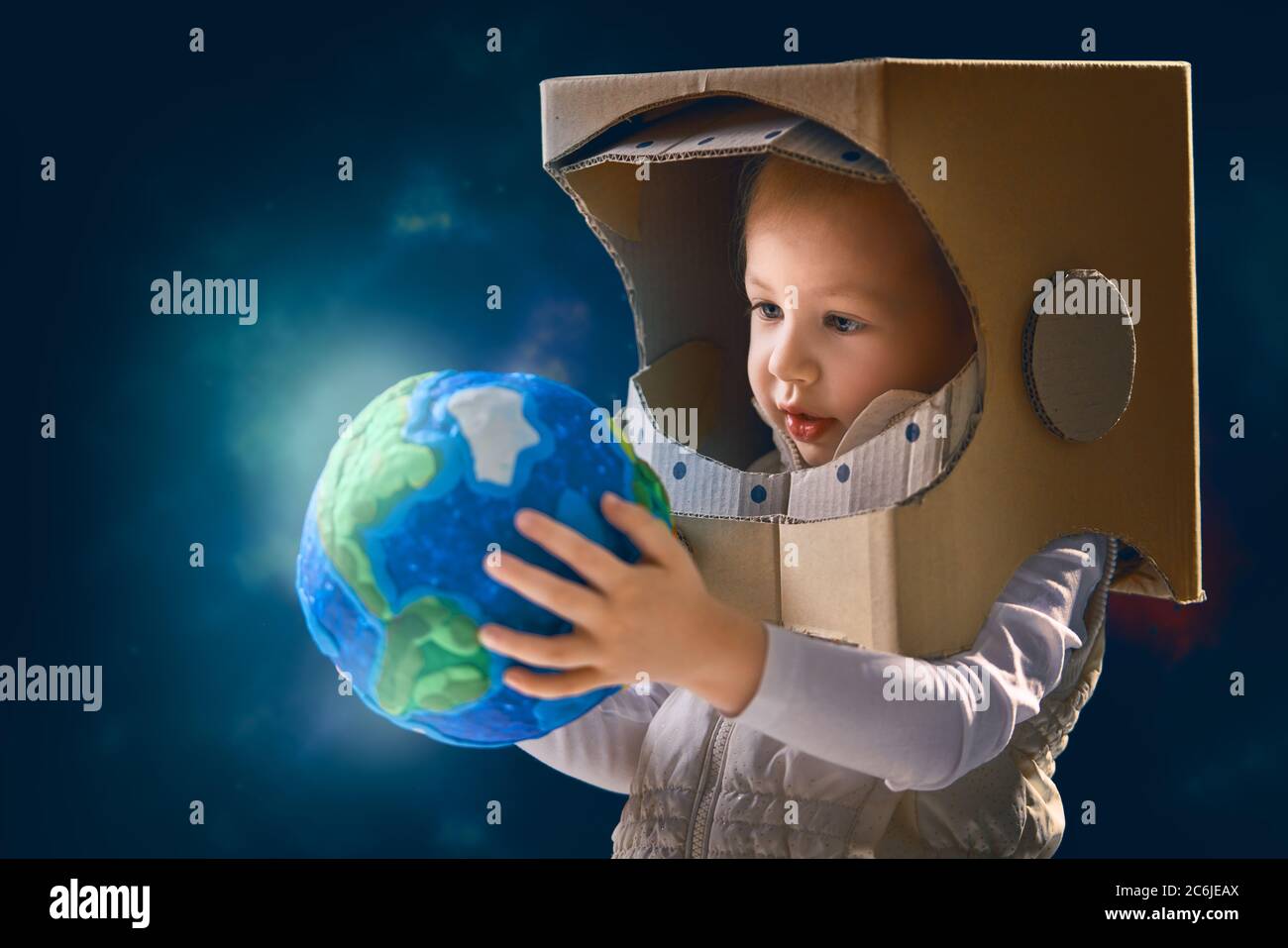 Kind ist in einem Astronauten-Kostüm gekleidet. Kind mit Globus. Tag der  Erde Stockfotografie - Alamy