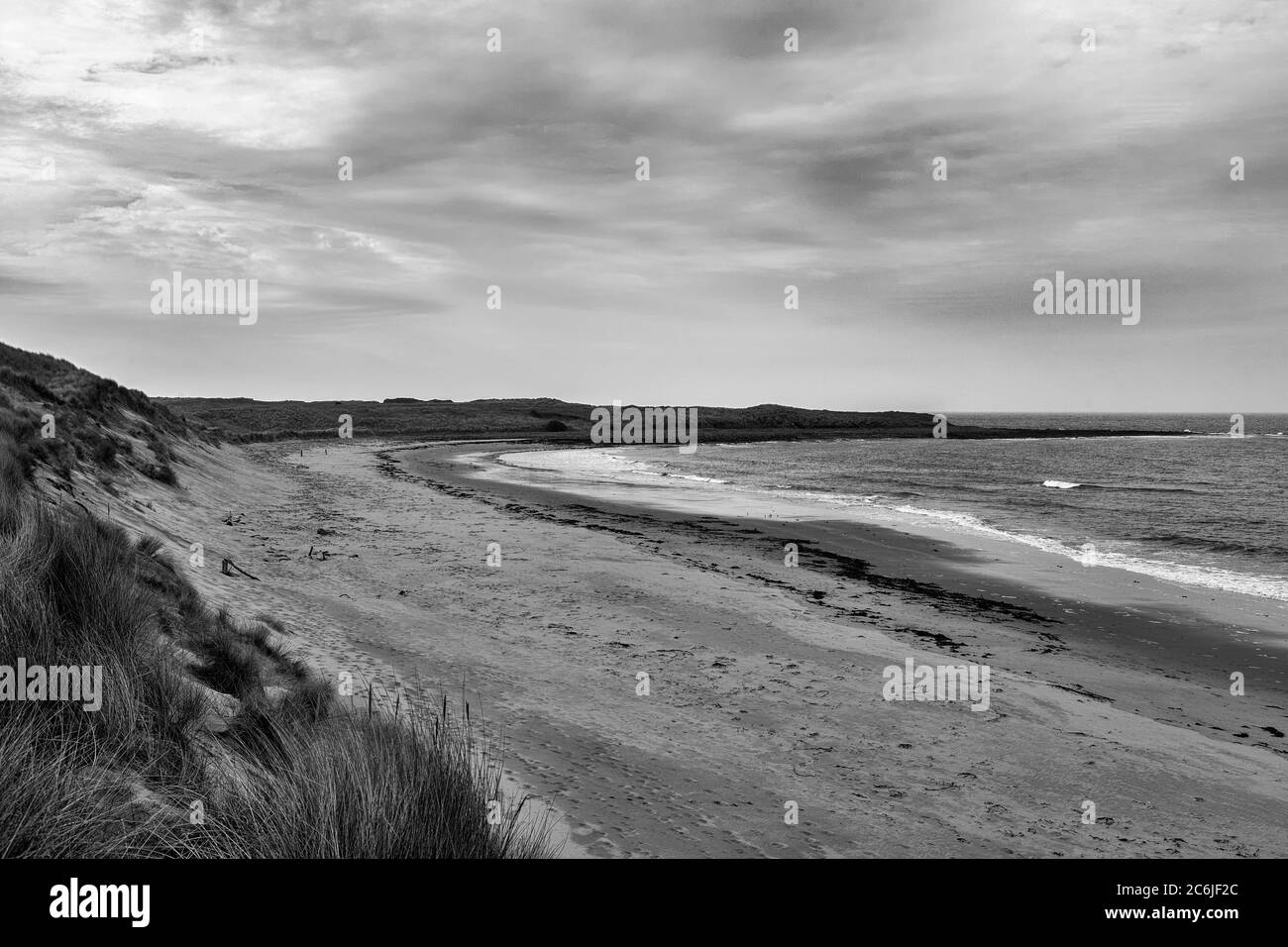 Ein ziemlich trostloser und leerer Nordseestrand: Sandham Bay, Holy Island of Lindisfarne, Northumberland, England, UK. Schwarz-Weiß-Version Stockfoto