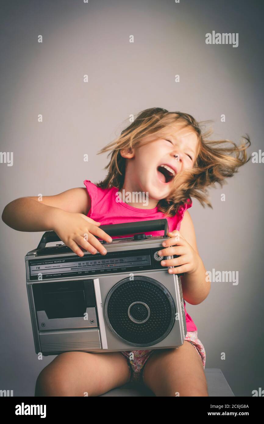 Kleines Mädchen hat Spaß, Musik mit einem alten 80er Jahre Radio hören Stockfoto