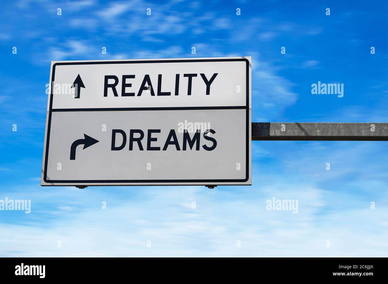 Realität versus Träume. Straßenschild mit Worten Realität und Träume. Weiße zwei Straßenschilder mit Pfeil auf Metallmast. Richtungsstraße. Kreuzungen Stockfoto