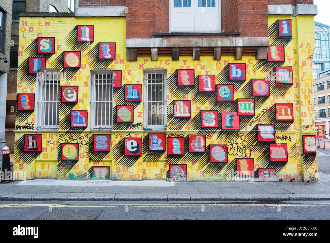 'Alphabet House' Street Art von Ben eine - bunte Buchstaben auf einer gelben Wand in Spitalfields, East London, UK Stockfoto