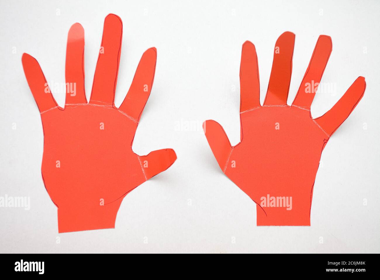 Childs schneiden Karton rote Hände auf weißem Hintergrund Stockfoto