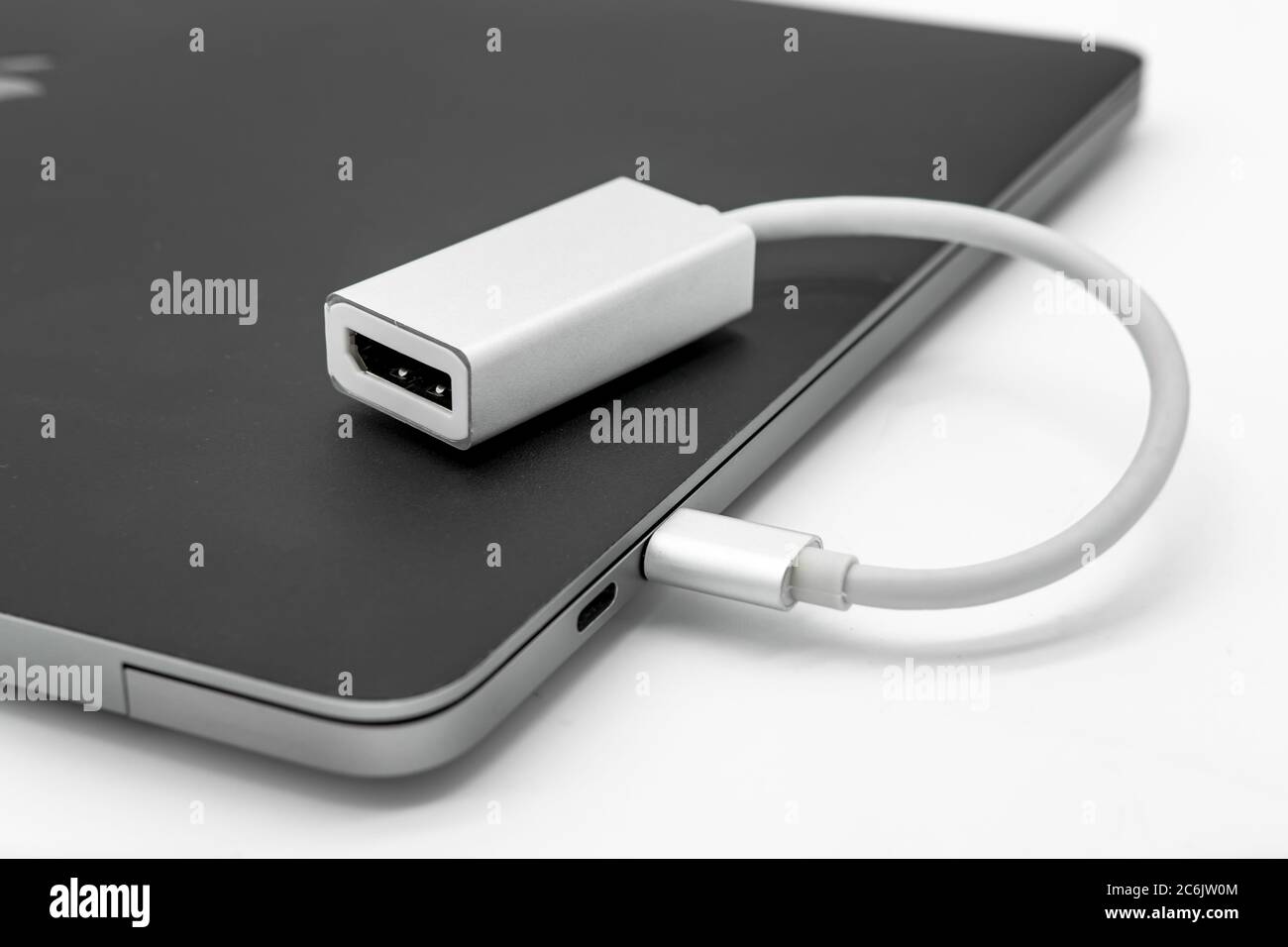 Isolierte Ansicht eines MDP-Display-Adapters, der an einen bekannten Laptop und eine digitale Lifestyle-Manufaktur angeschlossen ist. Wird für den Anschluss an ein externes Display verwendet Stockfoto