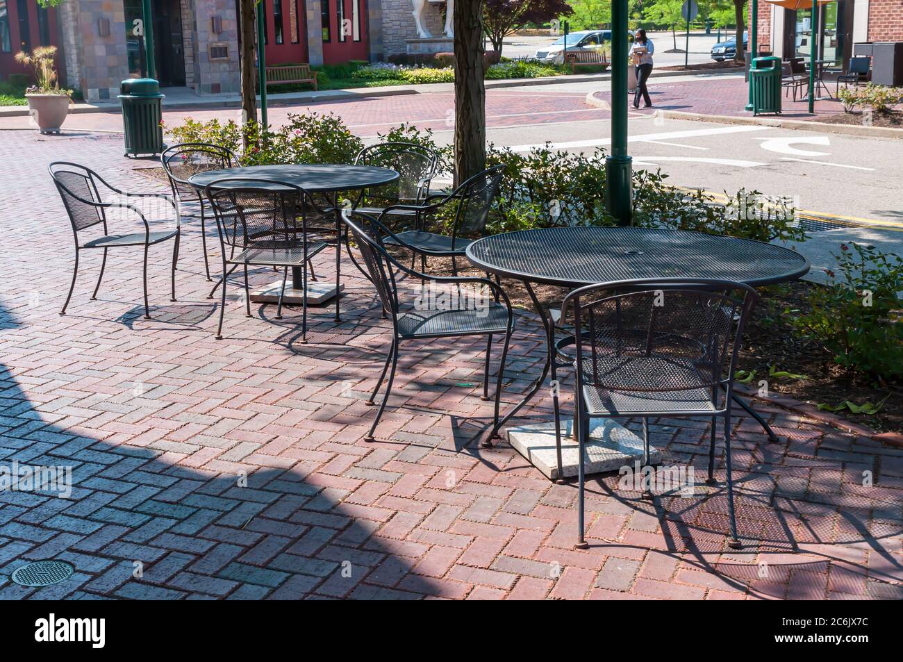 Tische und Stühle in einem schattigen Bereich auf einem Bürgersteig im Waterfront Shopping Complex an einem sonnigen Sommertag, Homestead, Pennsylvania, USA Stockfoto