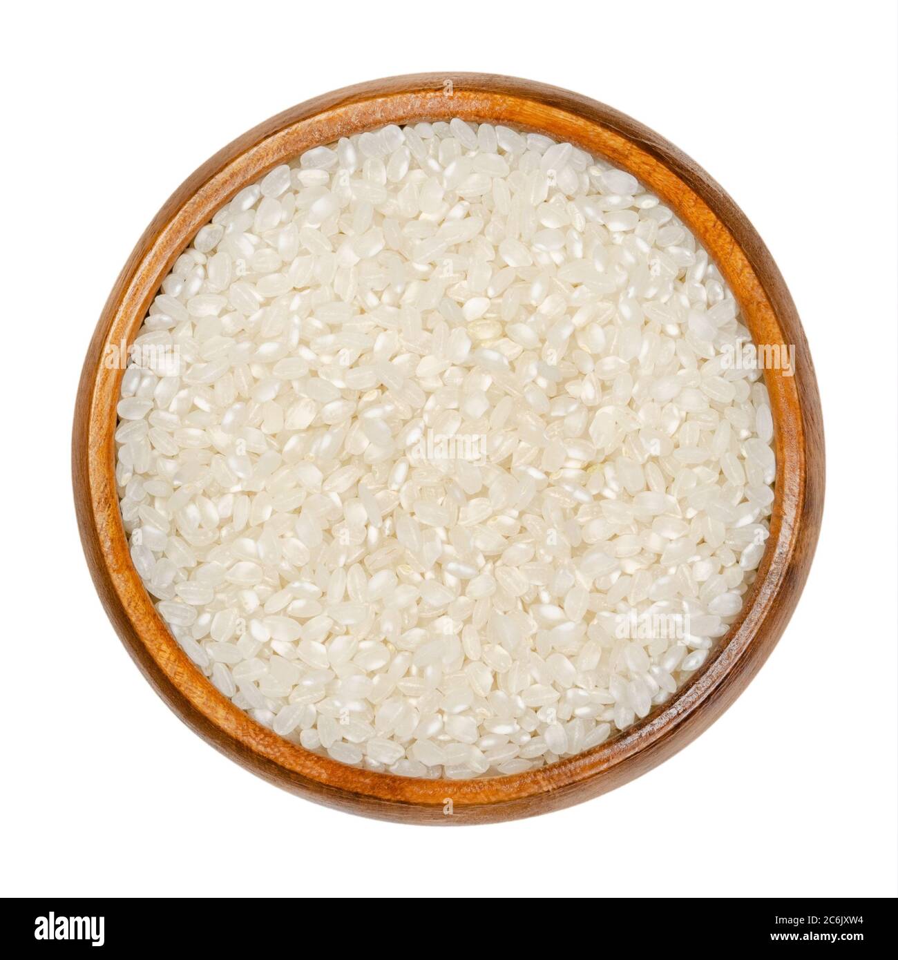 Weißer Kurzkornreis in Holzschüssel. Samen des Grases Oryza sativa, auch als asiatischer Reis bekannt. Getreide und Grundnahrungsmittel. Stockfoto