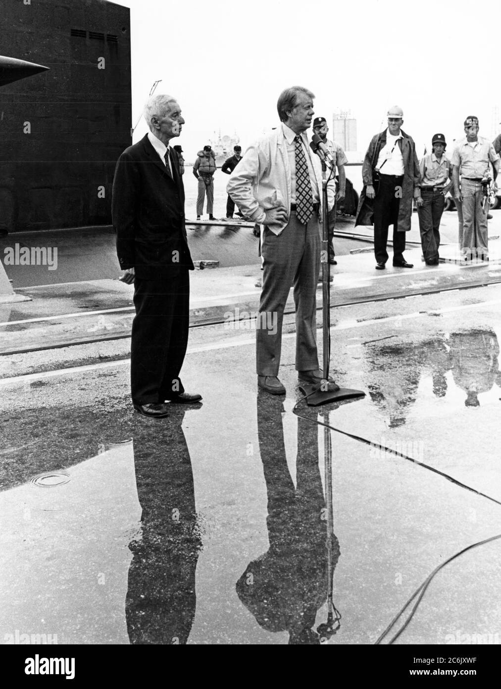 CAPE CANAVERAL, Florida (27. Mai 1977) Präsident Jimmy Carter hält eine Pressekonferenz nach seiner neunstündigen Kreuzfahrt an Bord des nuklearen U-Bootes USS Los Angeles (SSN 688) ab. Der Präsident wurde von ADM begleitet. Hyman G. Rickover, pensioniert, Direktor, Abteilung für Naval Reactors, US Energy Research and Development Administration und stellvertretender Kommandant für nukleare Antriebstechnik, links, Und First Lady Rosalynn Carter auf der Kreuzfahrt.CAPE CANAVERAL, Florida (27. Mai 1977) Präsident Jimmy Carter unterstützt First Lady Rosalynn Carter, während sie durch das Periskop des nuklearen U-Bootes USS L schaut Stockfoto