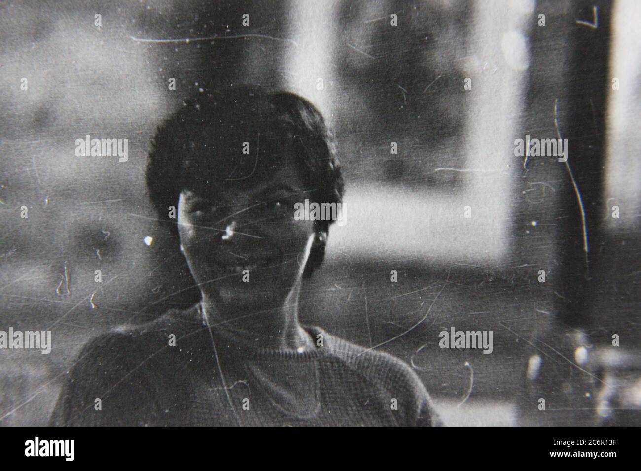 Schönes Schwarz-Weiß-Foto aus den 1970er Jahren von einer Frau mittleren Alters, die glücklich die Zeit herumsitzt. Stockfoto