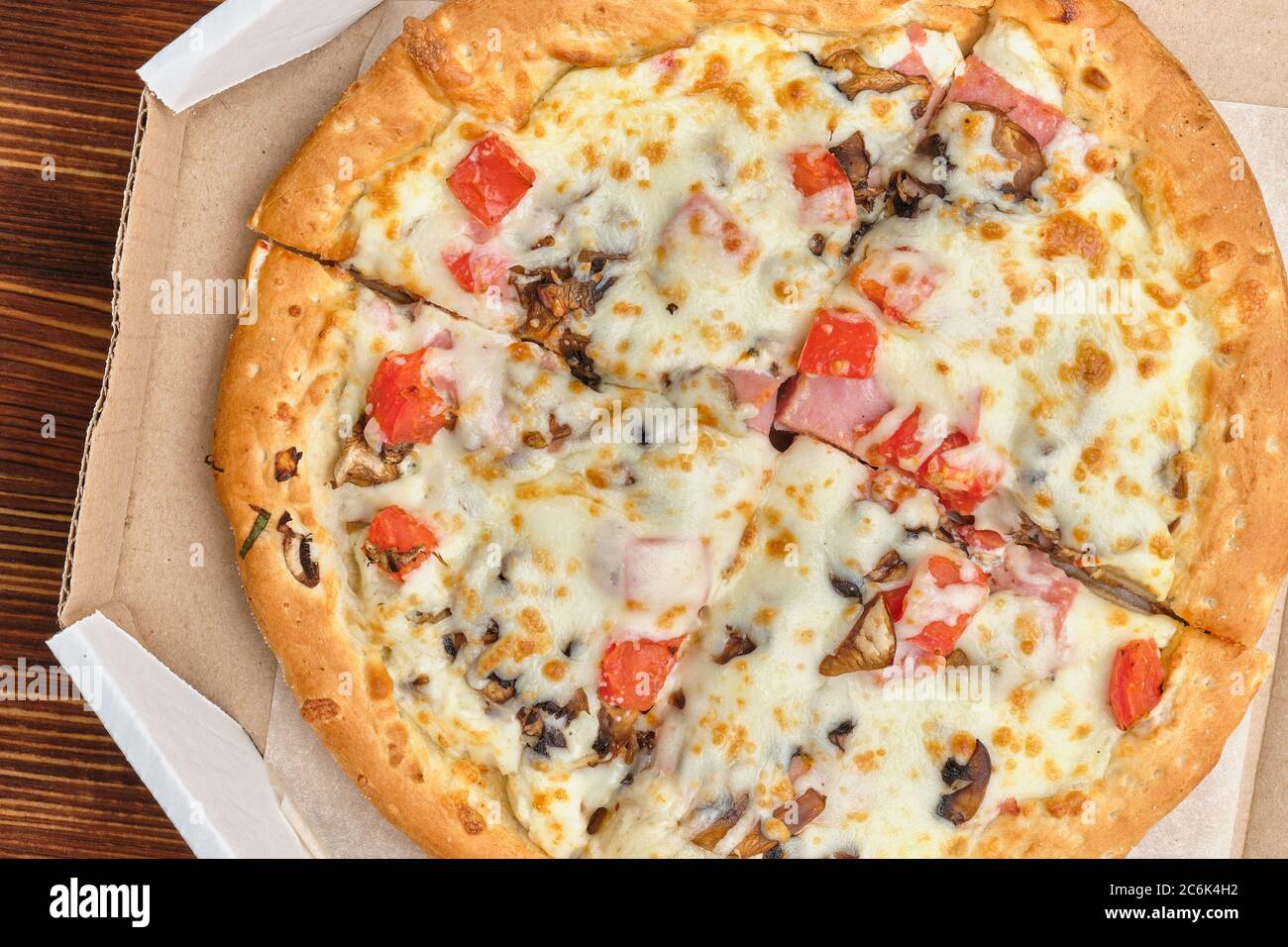 Carbonara Pizza in Kartonpackungen auf Holzhintergrund. Stockfoto