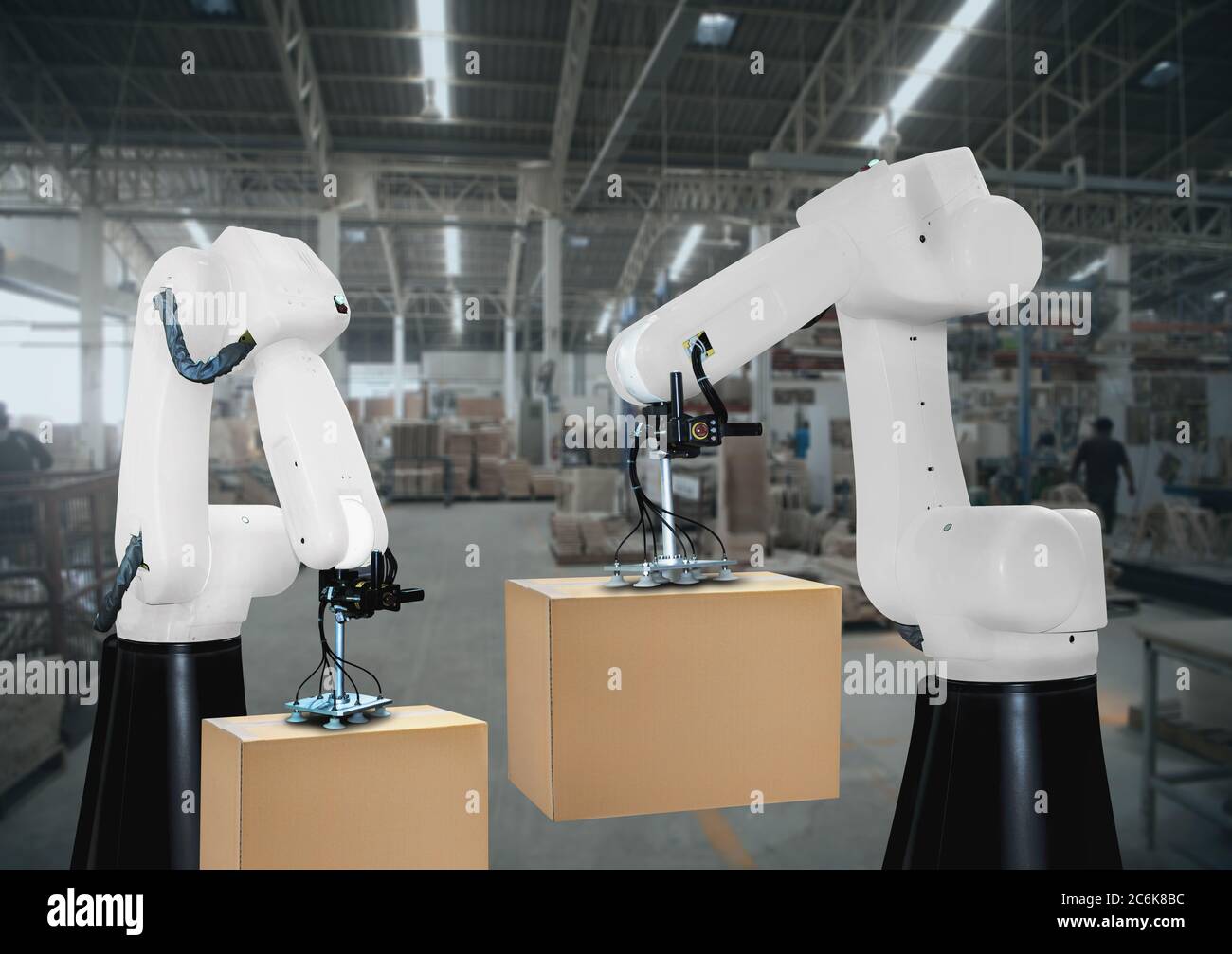 Die Roboterarme tragen Kartonagen für die Belieferung der Industrie Stockfoto