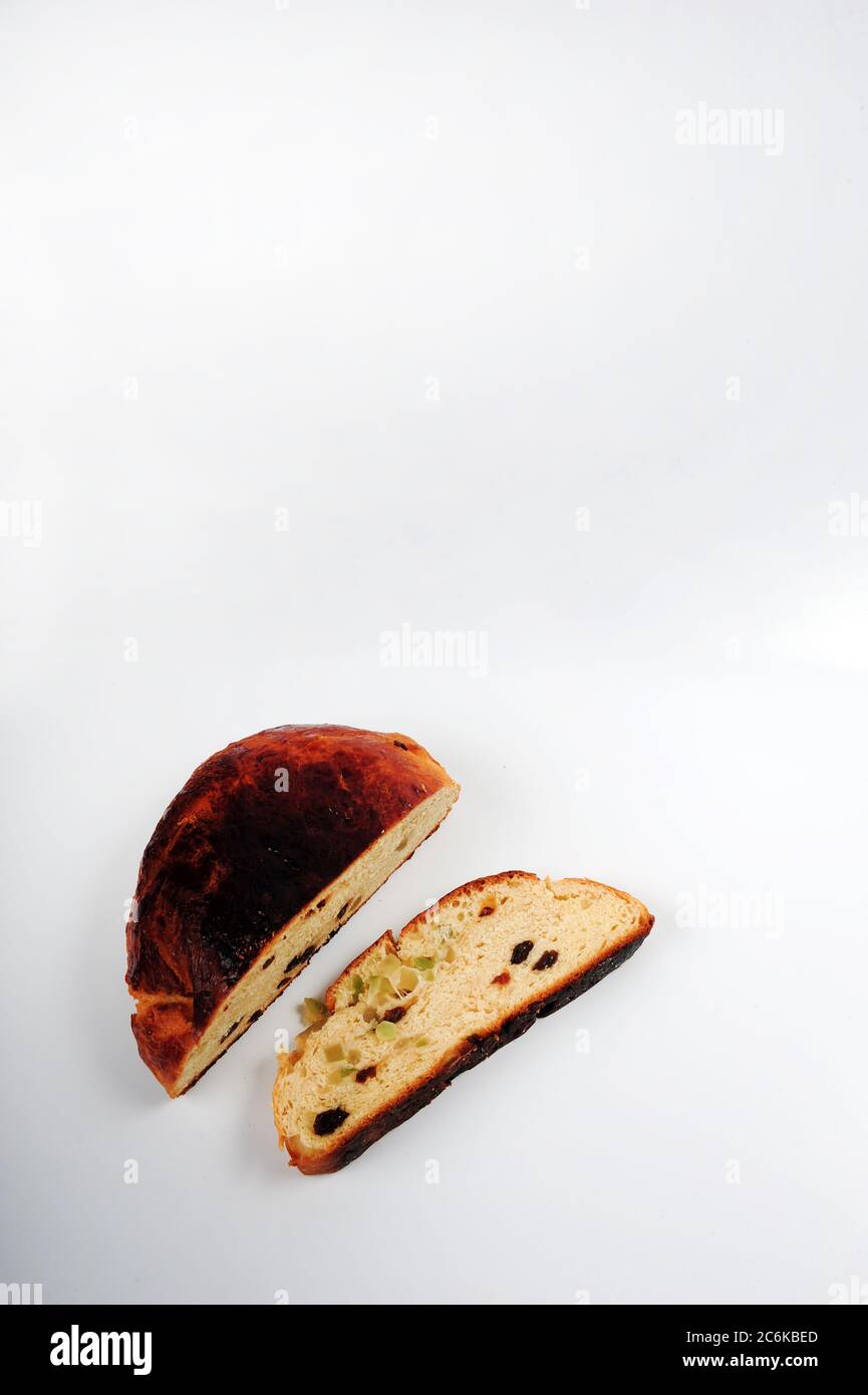 Norwegischer Weihnachtskuchen mit Rosinen und kandierten Schalen. Rundes Brot mit einer Scheibe auf der Seite. Vertikale Aufnahme mit Kopierbereich im oberen Teil des Fotos Stockfoto
