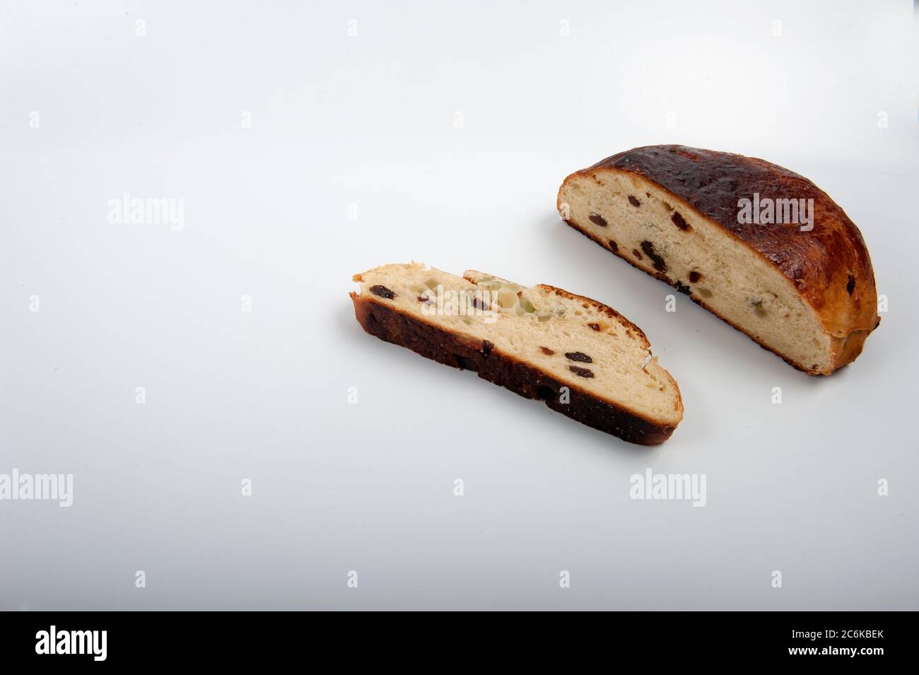 Norwegischer Weihnachtskuchen mit Rosinen und kandierten Schalen. Rundes Brot mit einer Scheibe auf der Seite. Horizontale Aufnahme mit Kopierraum im linken Teil des Phot Stockfoto