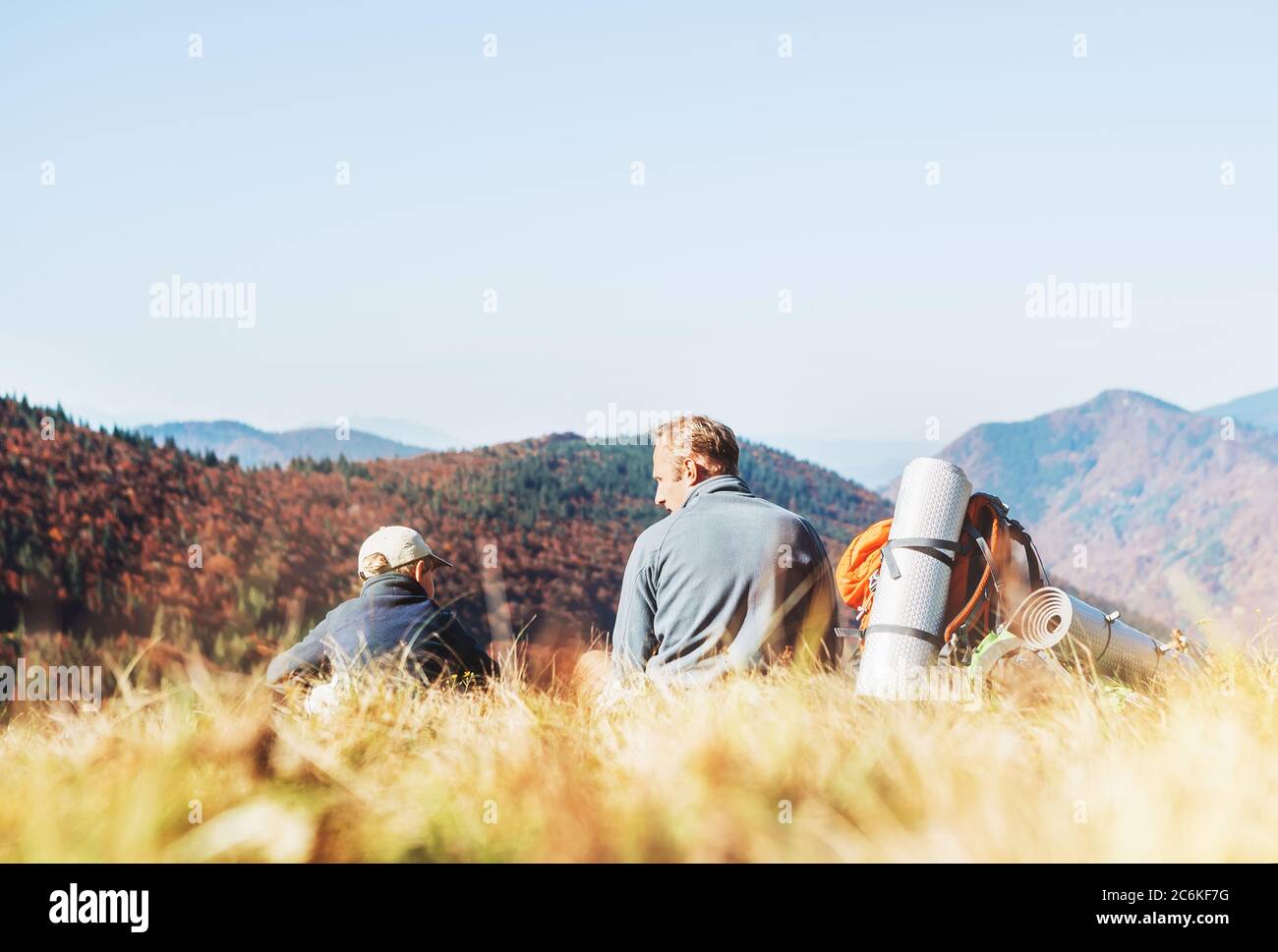 Vater mit Sohn Rucksacktouristen Wanderer ruhen auf dem Berg und genießen Niedere Tatra Landschaft mit ihrem Beagle Hund. Bergwandern mit Kindern und Haustier Stockfoto