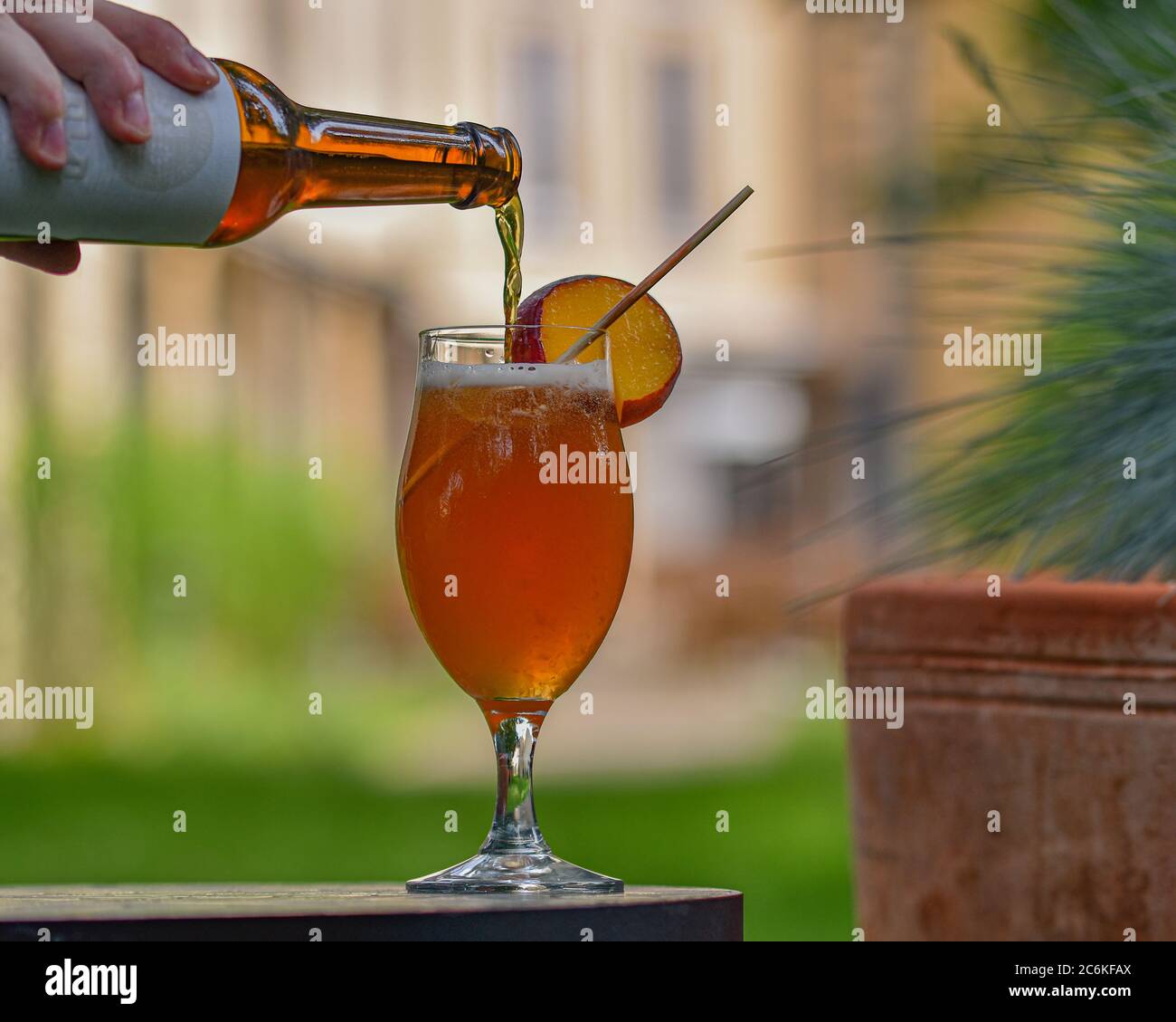 Sommercocktail mit alkoholfreiem Craft-Bier, Grapefruit und Pfirsich in ein Glas gegossen Stockfoto