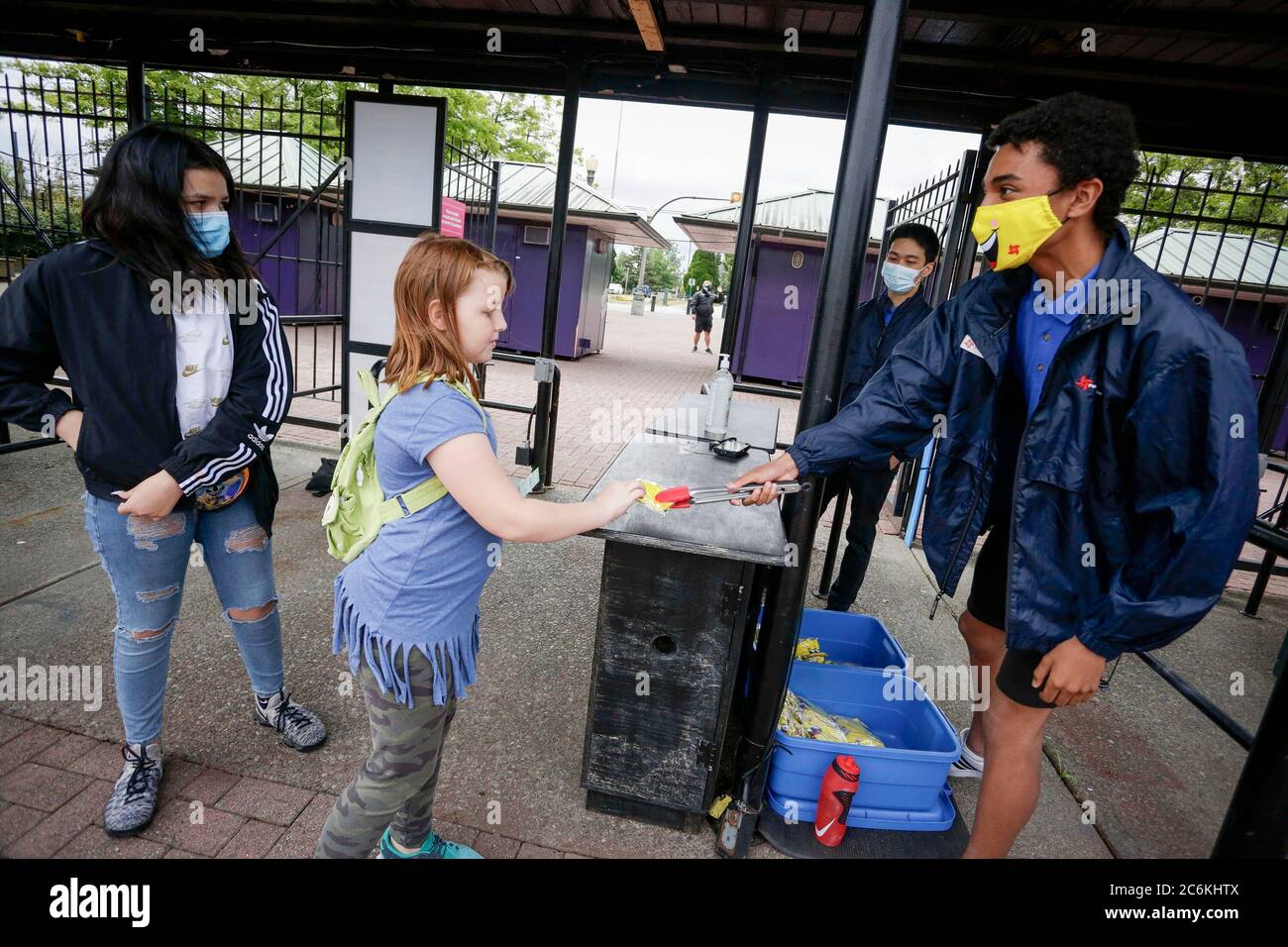 Vancouver, Kanada. Juli 2020. Ein Mitarbeiter verteilt eine kostenlose Maske an einen Besucher am Eingang zum Playland Amusement Park auf der Pacific National Exhibition in Vancouver, British Columbia, Kanada, am 10. Juli 2020. Der Playland Amusement Park wurde am Freitag für die Öffentlichkeit wieder geöffnet, mit Maßnahmen, um angemessene Gesundheits- und Sicherheitsprotokolle im gesamten Park zu gewährleisten. Quelle: Liang Sen/Xinhua/Alamy Live News Stockfoto
