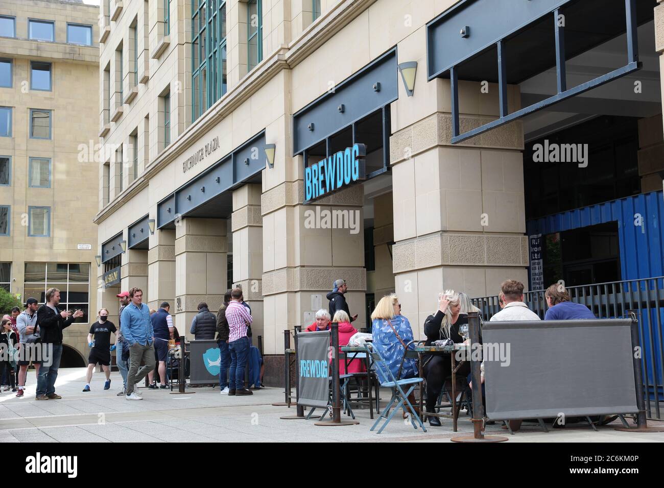 Menschen, die in der Warteschlange stehen, um in eine Brewdog Bar zu kommen, und Menschen, die auf der Terrasse sitzen und trinken, nachdem die schottische Coronavirus-Lockdown-Lockerung durchgeführt wurde Stockfoto
