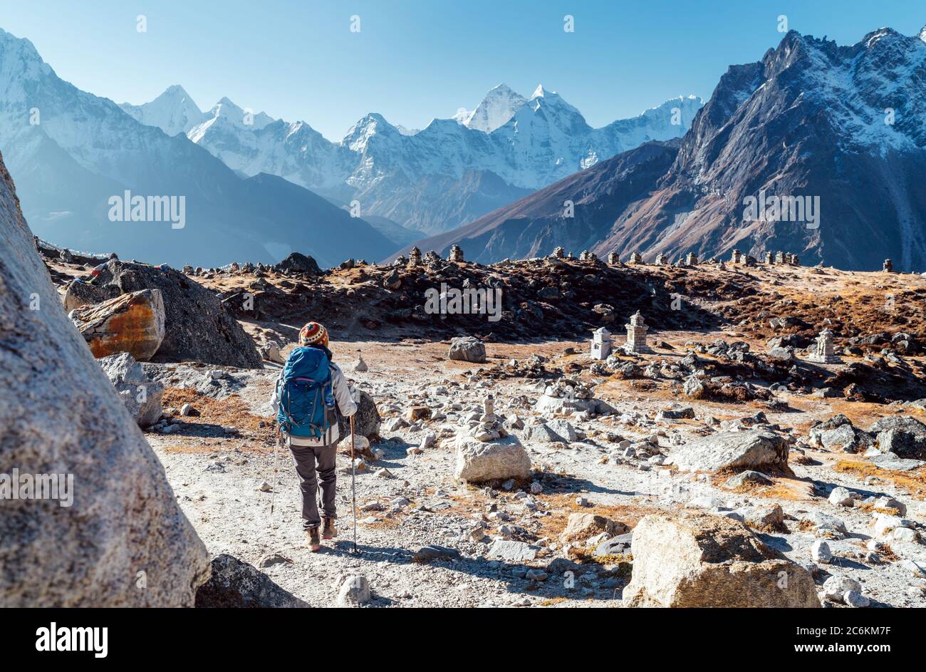 Junge Backpacker-Frau auf der Everest Base Camp Trekkingroute mit Trekkingstöcken und Blick auf das Tal mit Ama Dablam Gipfel. Sie kam zu Eva Stockfoto