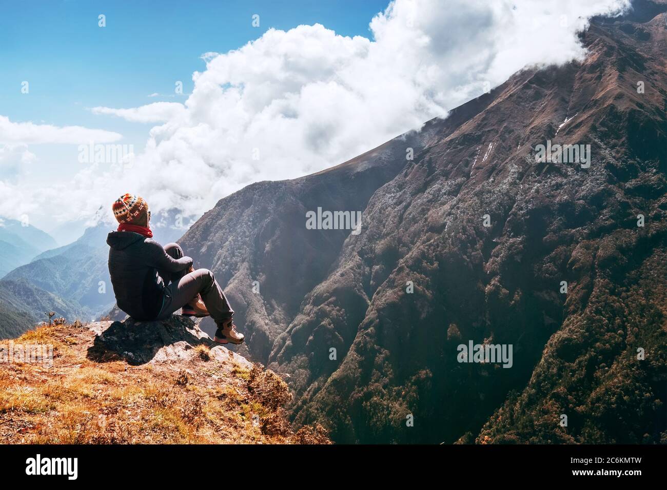 Junge Wandererin Backpacker sitzt am Gipfelrand und genießt das Bergpanorama Tal während der Höhenwanderung des Everest Base Camp (EBC) Stockfoto