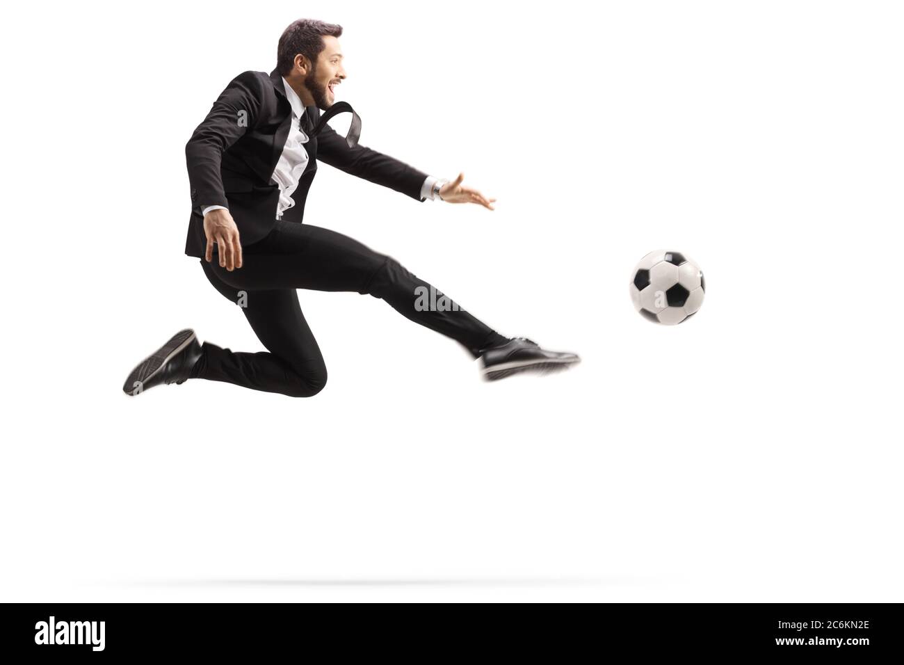 Mann in einem Anzug springen und treten einen Fußball isoliert auf weißem Hintergrund Stockfoto