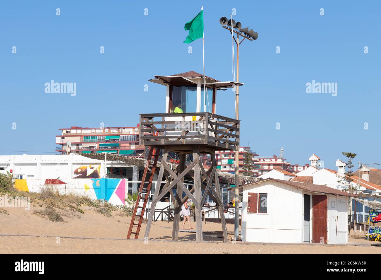 Punta Umbria, Huelva, Spanien - 9. Juli 2020: Ein Rettungsschwimmer sitzt auf einem Überwachungsturm am Strand von Punta Umbria, Huelva, Spanien Stockfoto
